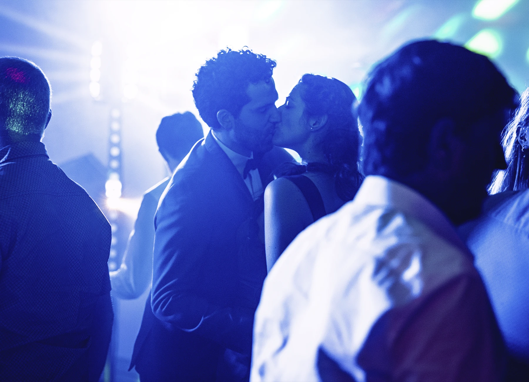 Couple s'embrassant sous une lumière bleue et verte lors de la soirée dansante à Quesmy, photographie par Laurène Zabary