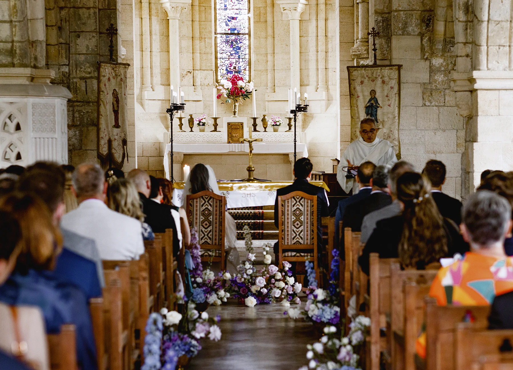 Plan large des mariés de dos dans l'église de Quesmy. Photo par Laurène Zabary.
