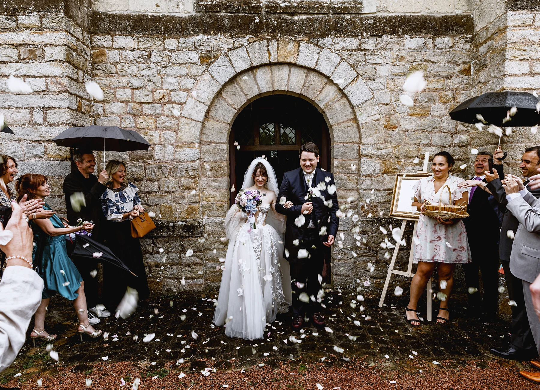 Sortie des mariés de l'église de Quesmy sous un lancé de pétales. Photo par Laurène Zabary.