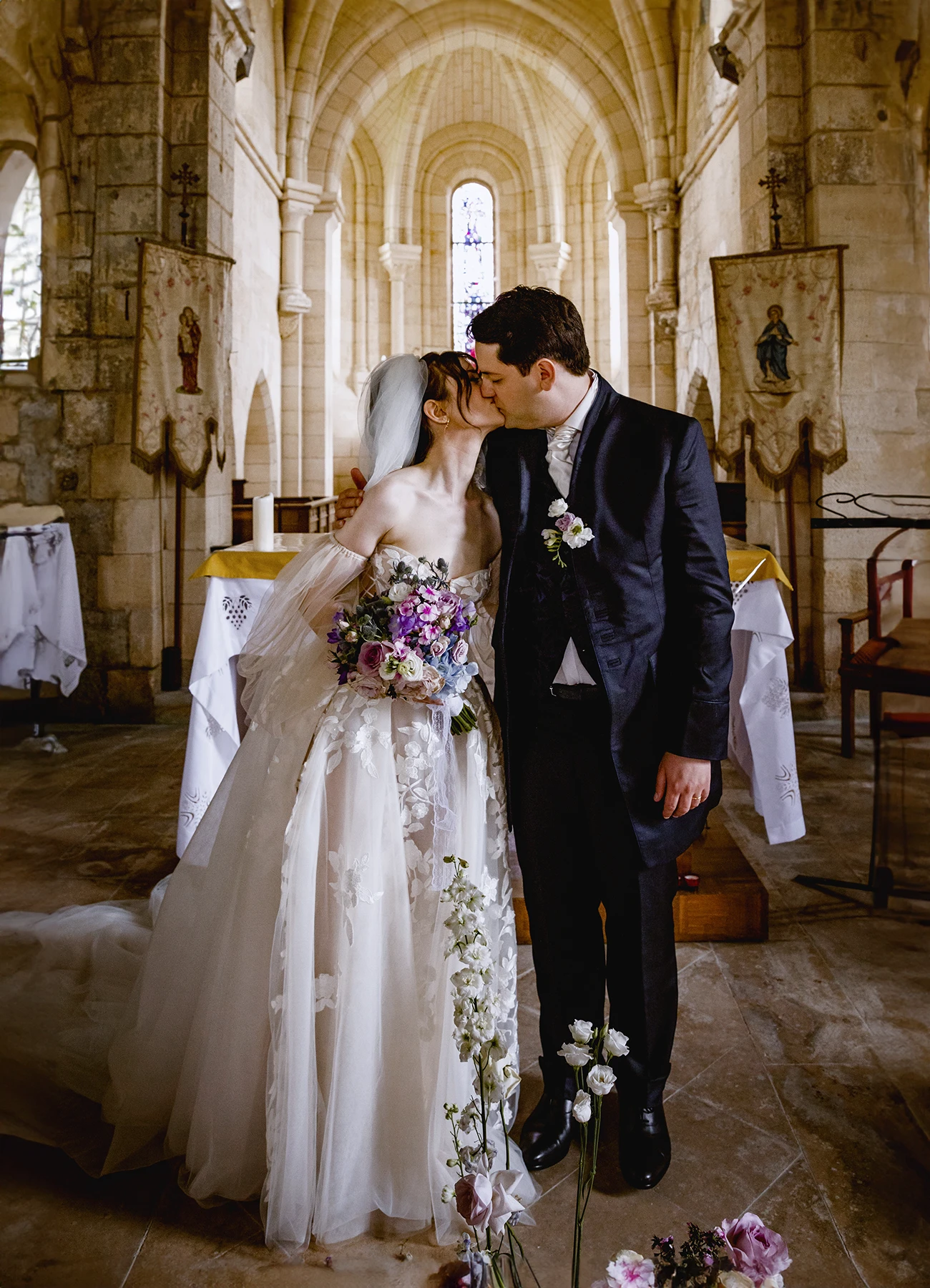 Couple de mariés s'embrassant à l'église de Quesmy. Photo par Laurène Zabary.