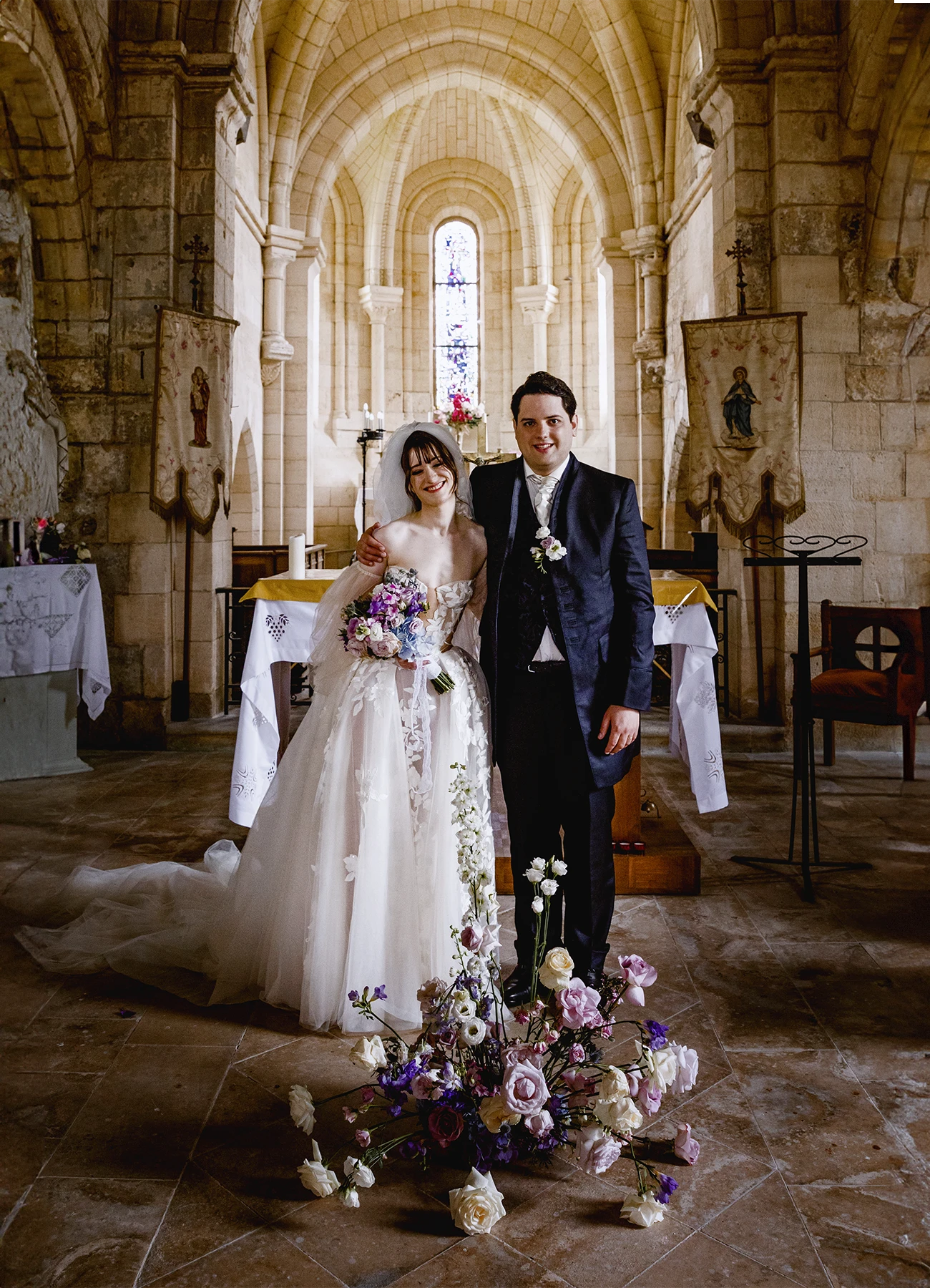 Mariés souriants face à l'objectif à l'église de Quesmy. Photo par Laurène Zabary.