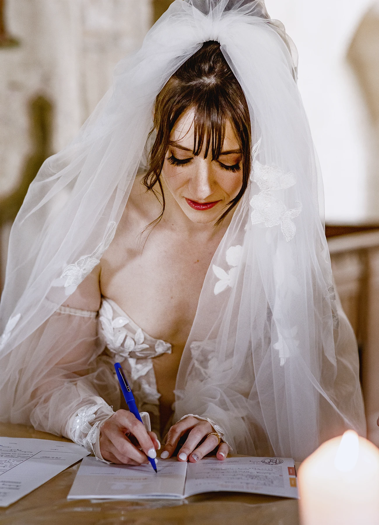 Mariée signant l'acte de mariage à l'église de Quesmy. Photo par Laurène Zabary.