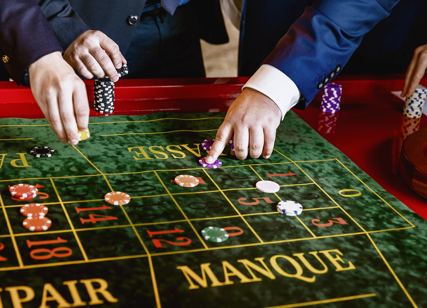 Gros plan sur des mains plaçant des paris à la roulette au vin d'honneur