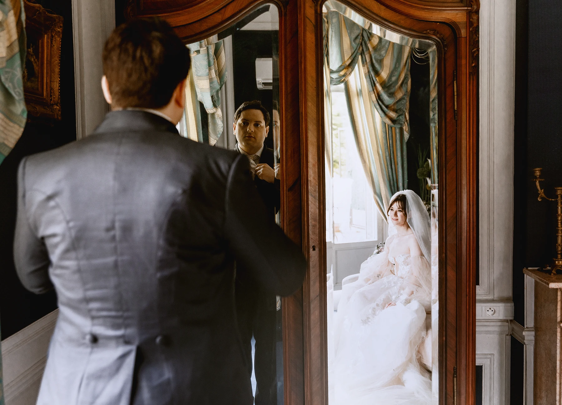Reflets du marié et de la mariée dans un miroir lors des préparatifs. Photo par Laurène Zabary.