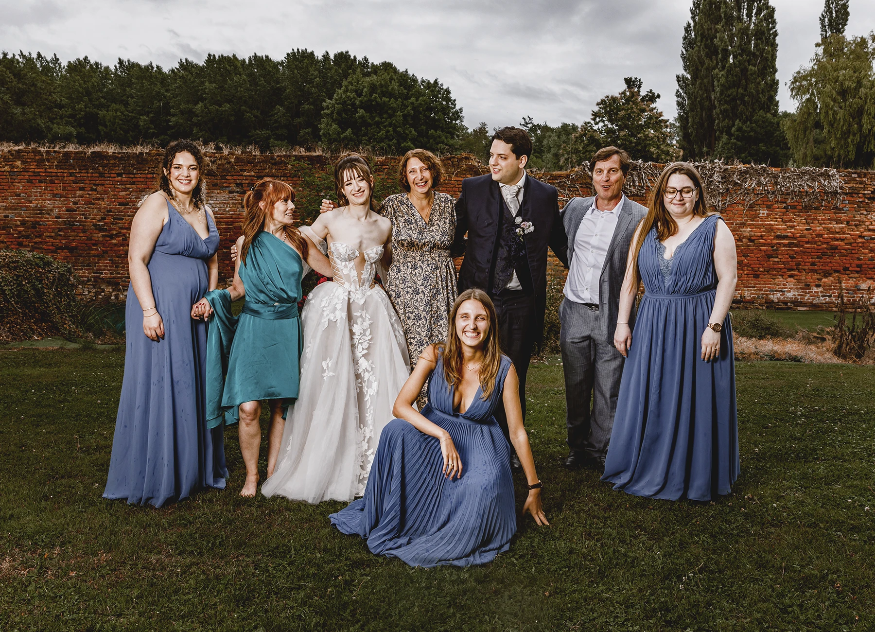 Mariés entourés de proches et demoiselles d'honneur en robes bleues à Quesmy, photo de groupe par Laurène Zabary