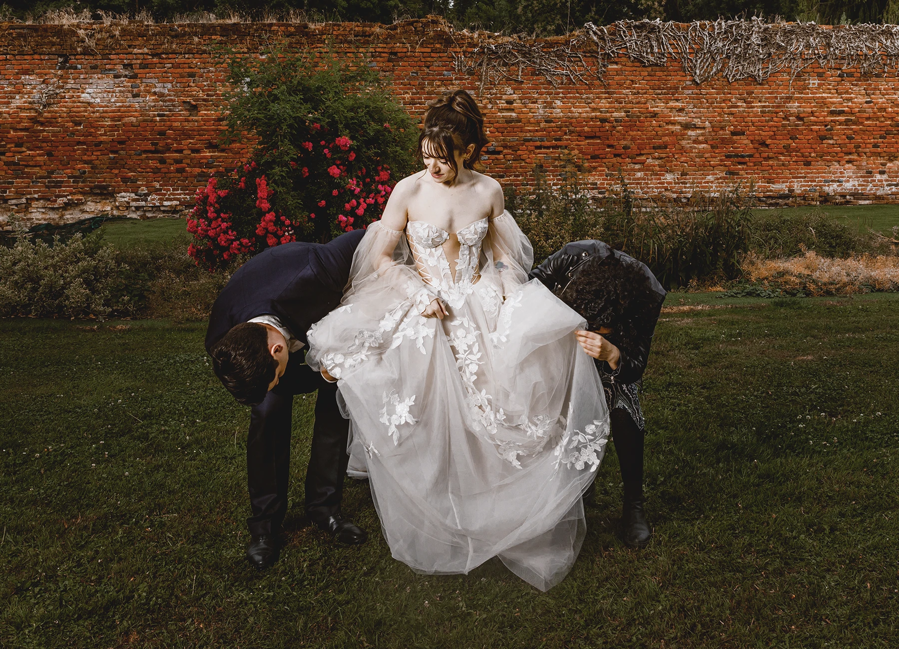Invités regardant sous la robe de la mariée de façon humoristique à Quesmy, photo de mariage par Laurène Zabary
