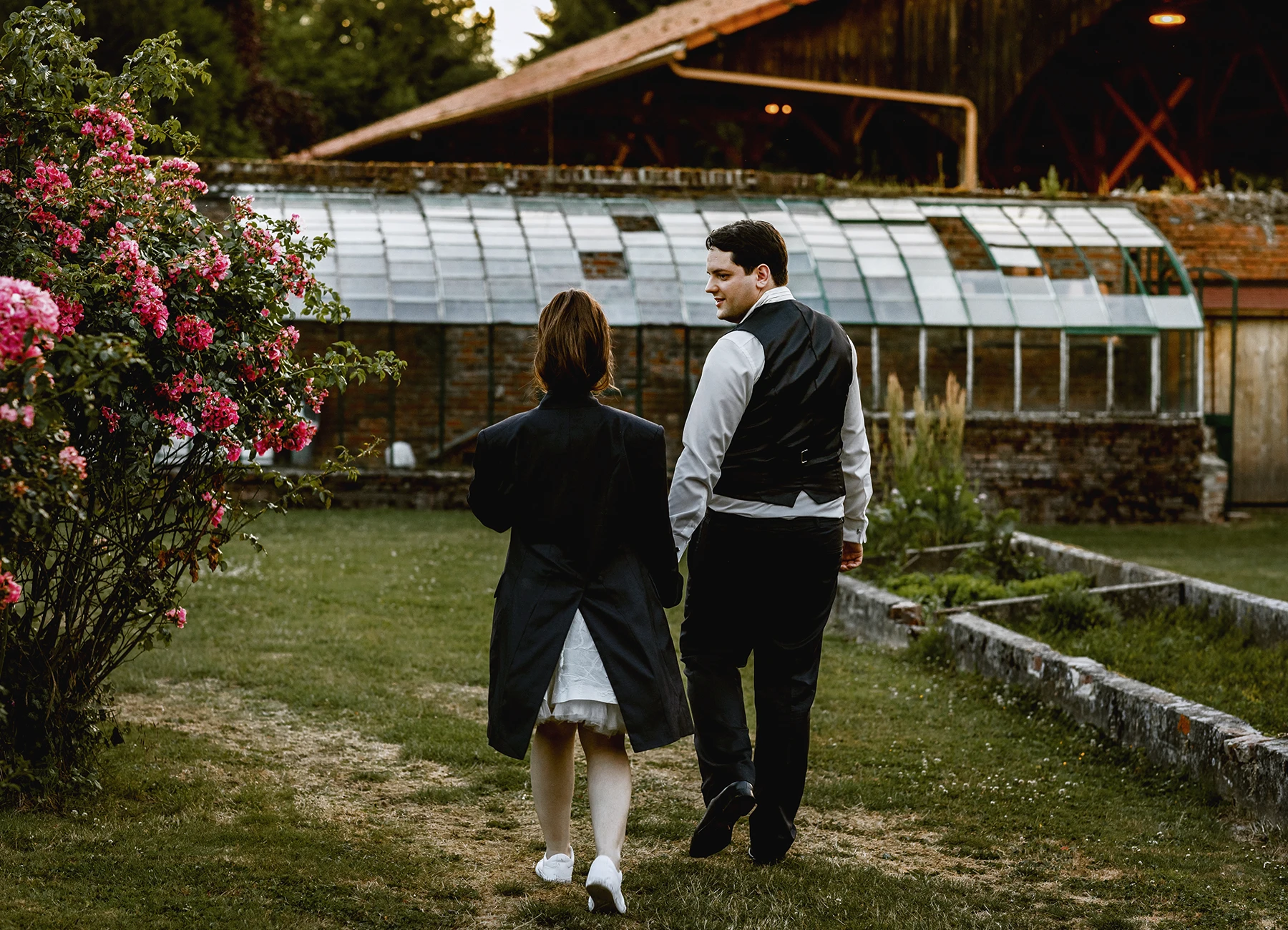 Mariés de dos se tenant par la main au château de Quesmy, photographie de mariage par Laurène Zabary