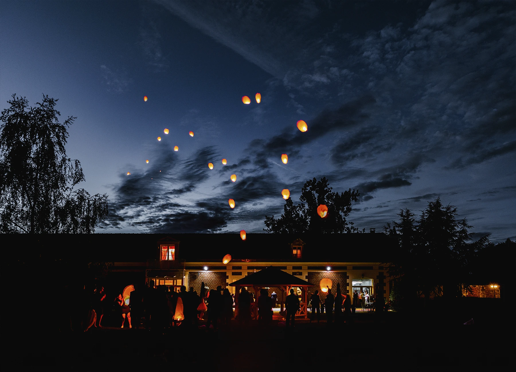 Lanternes chinoises flottant dans le ciel nocturne à Quesmy, photographie de mariage par Laurène Zabary