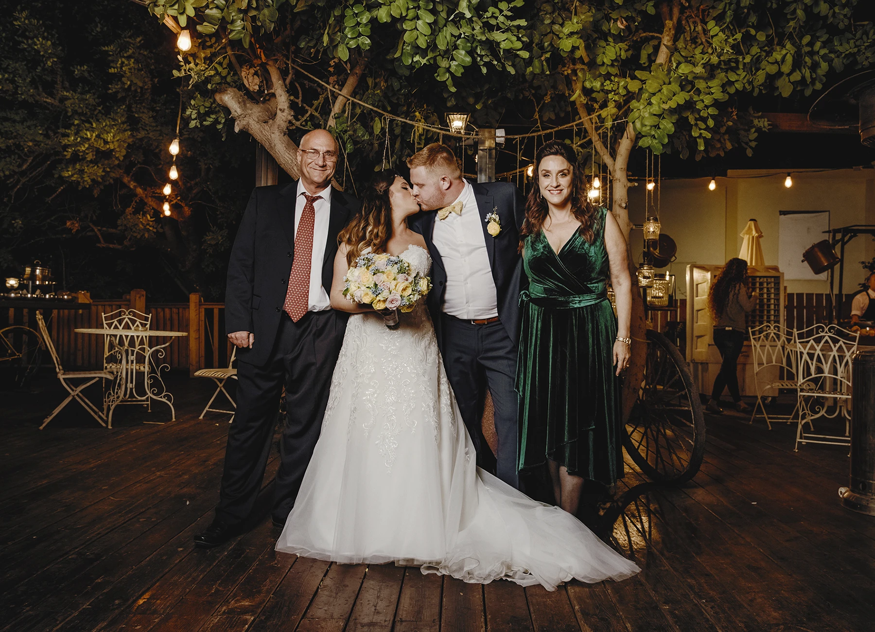 Mariés s'embrassant avec les parents de la mariée à leurs côtés - Laurène Zabary