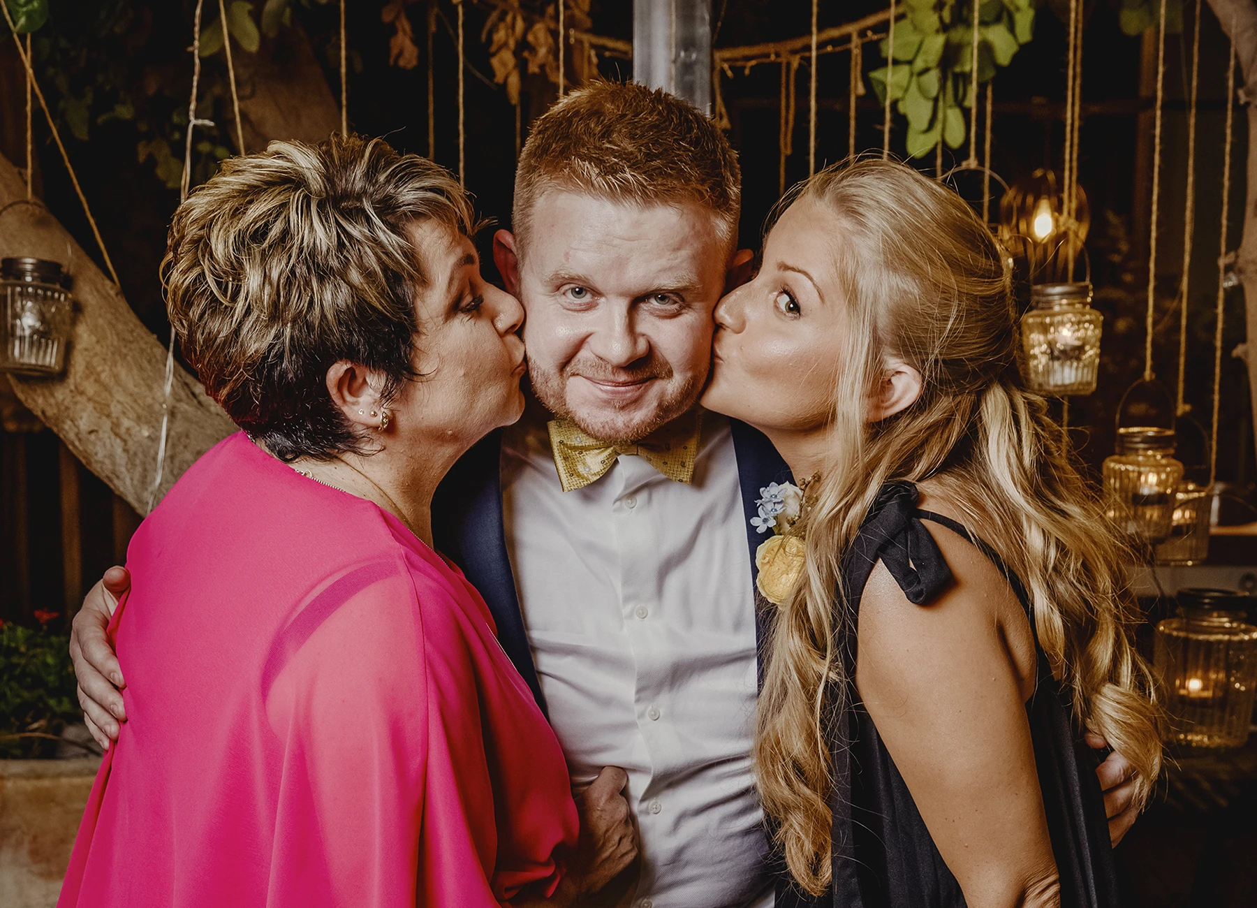 Marié souriant avec sa mère et sa sœur l'embrassant sur les joues - Laurène Zabary