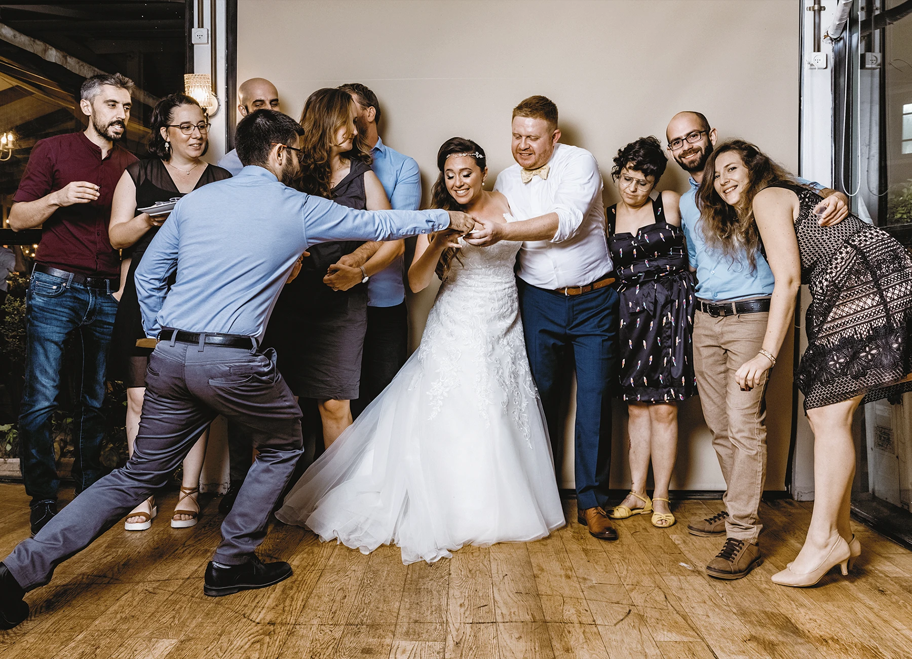 Mariés posant en groupe avec leurs invités pendant la soirée de mariage - Laurène Zabary
