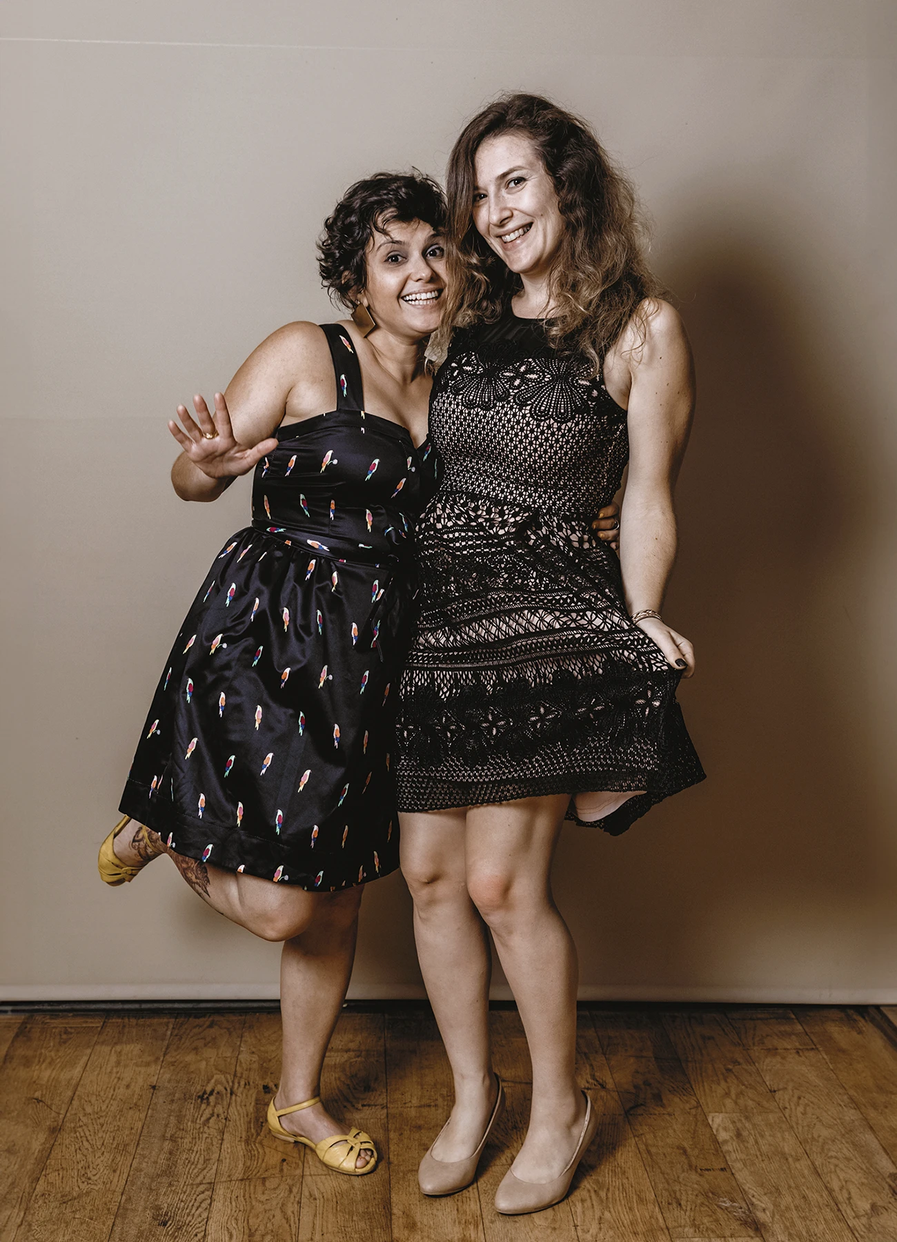 Deux femmes en train de poser ensemble sur fond uni beige lors de la soirée de mariage - Laurène Zabary