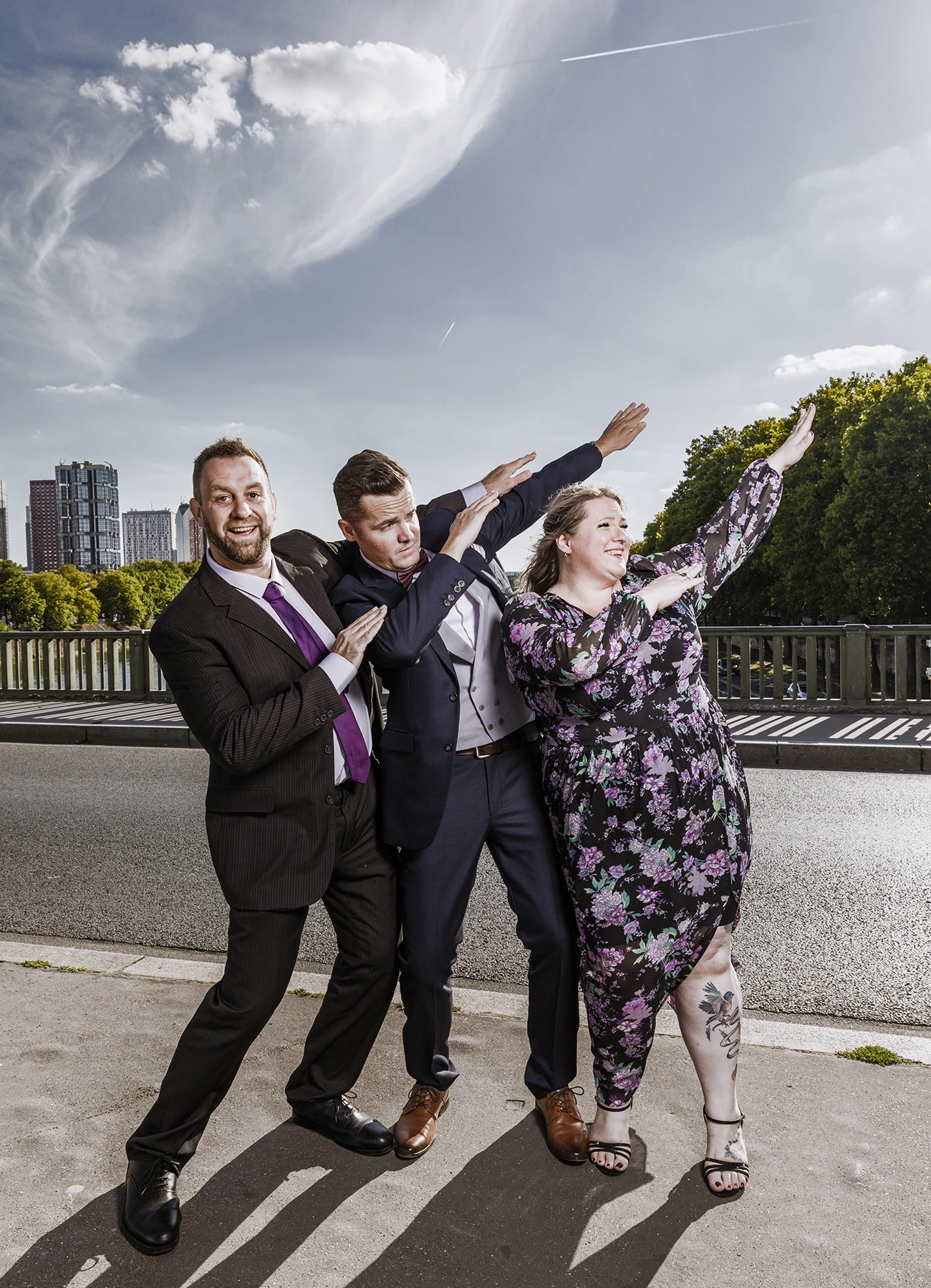 Mariés et amis pour une photo de groupe humoristique sur le pont Bir Hakeim à Paris, capturée par Laurène Zabary.
