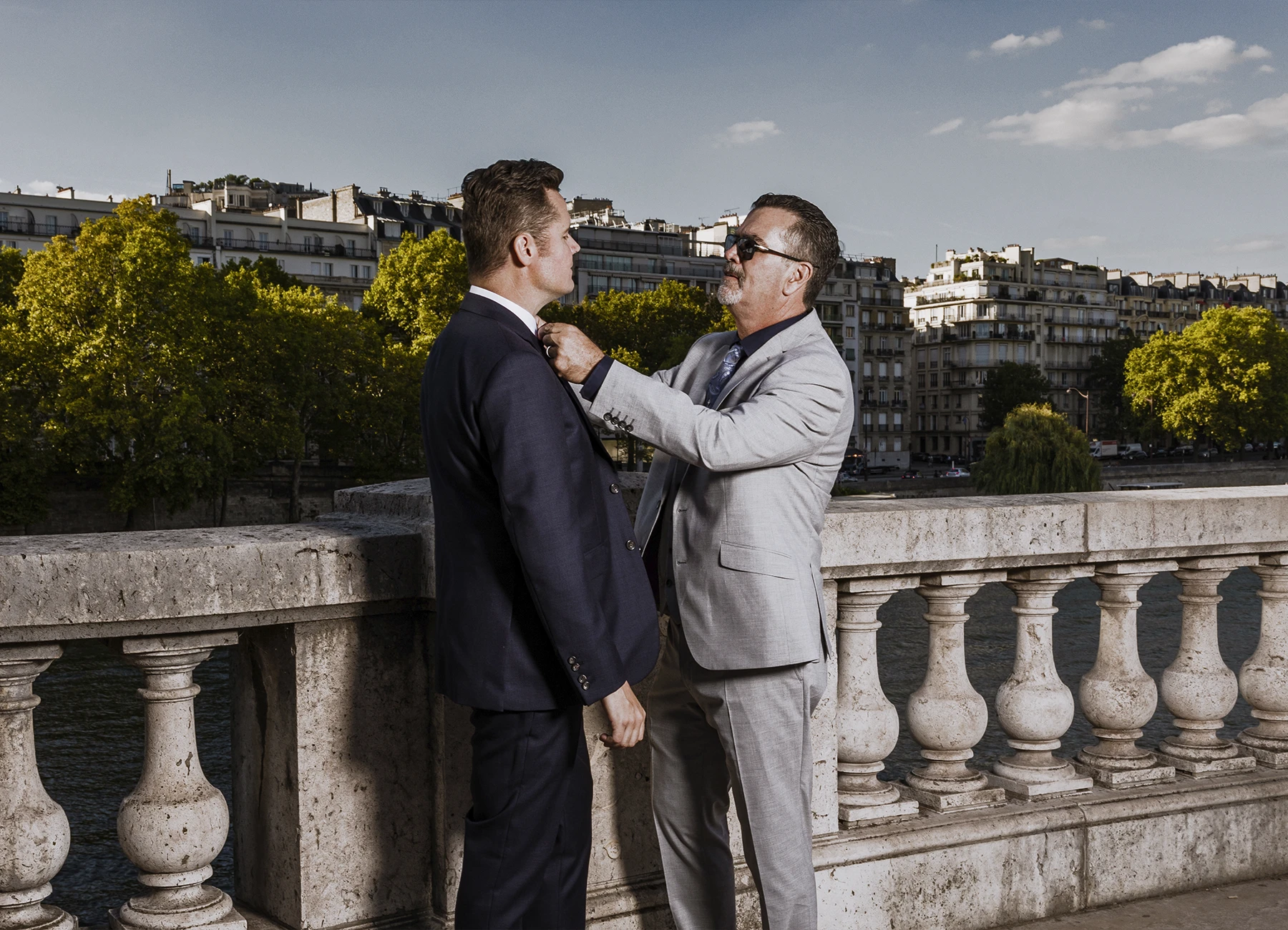 Marié se faisant réajuster son nœud papillon par son beau père sur le pont Bir Hakeim à Paris, photographié par Laurène Zabary