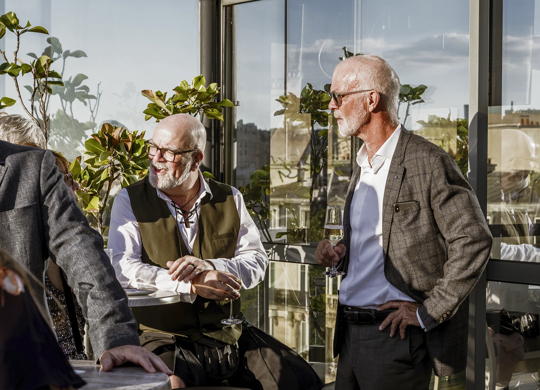 Invités dégustant du champagne au vin d'honneur du mariage au Rooftop Grenelle à Paris, photographiés par Laurène Zabary.