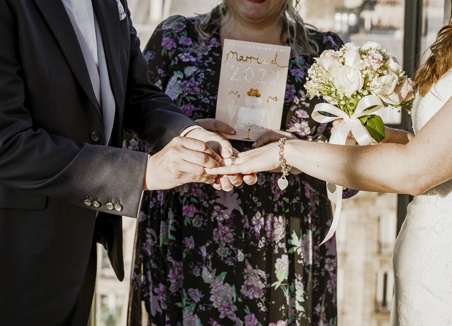 Focus sur les mains des mariés échangeant leurs alliances au Rooftop Grenelle à Paris, capturé par Laurène Zabary