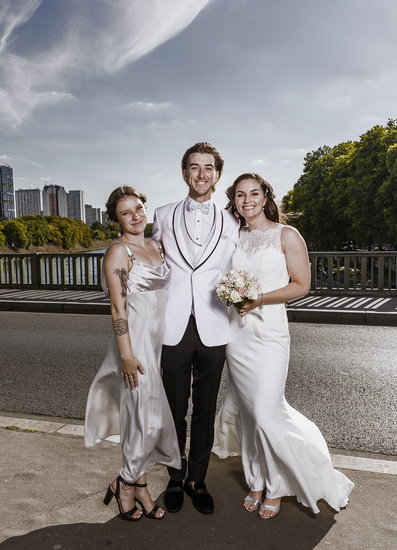 Photo de groupe classique sur le pont Bir Hakeim à Paris avec la mariée, son frère, et sa petite amie, capturée par Laurène Zabary