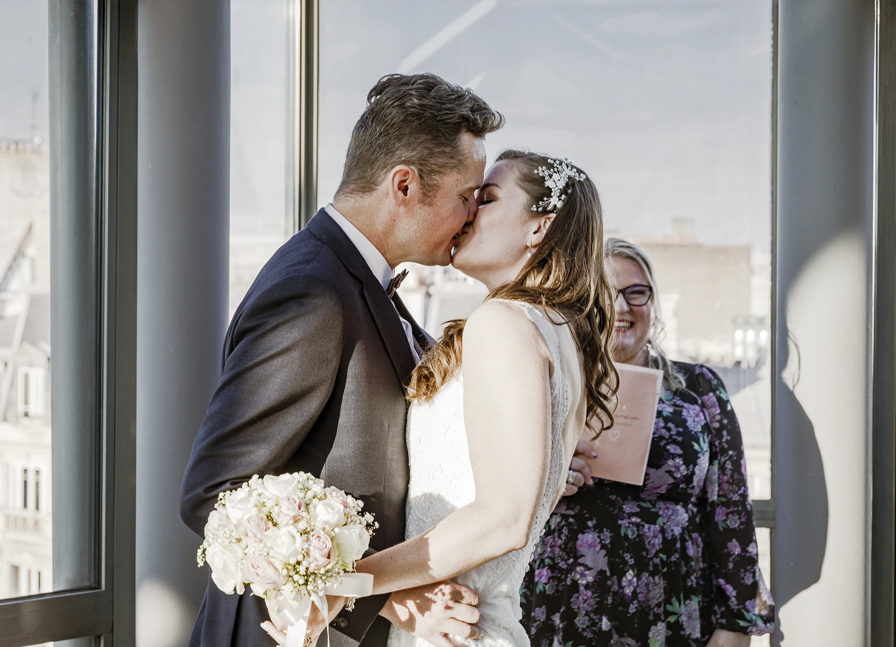 Plan serré des mariés s'embrassant à la fin de la cérémonie au Rooftop Grenelle à Paris, capturé par Laurène Zabary
