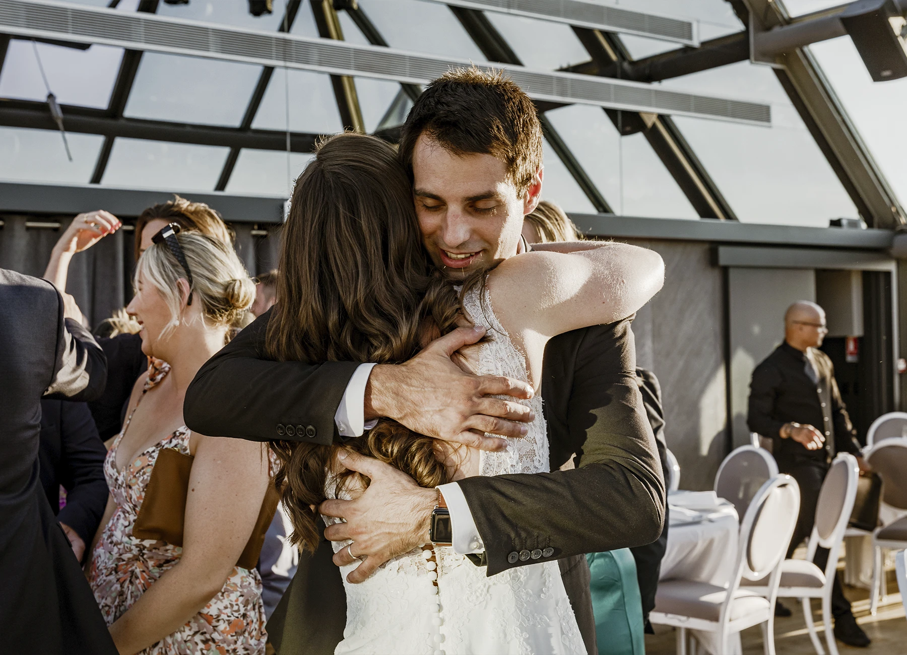 Mariée enlaçant un invité après l'office laïque au Rooftop Grenelle à Paris, capturée par Laurène Zabary.