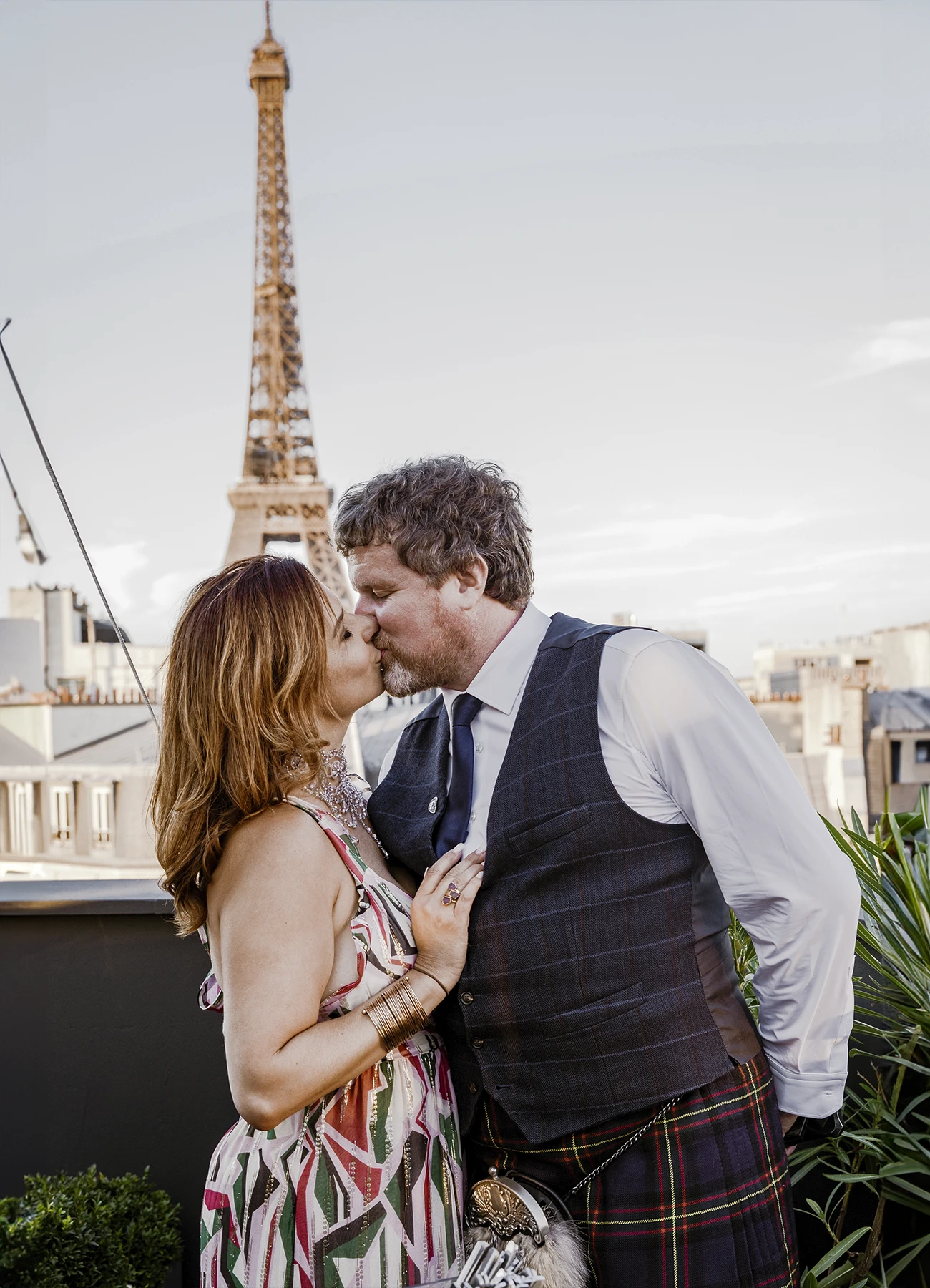 Couple d'invités s'embrassant sur la terrasse du Rooftop Grenelle à Paris, avec la tour Eiffel en arrière-plan, capturés par Laurène Zabary