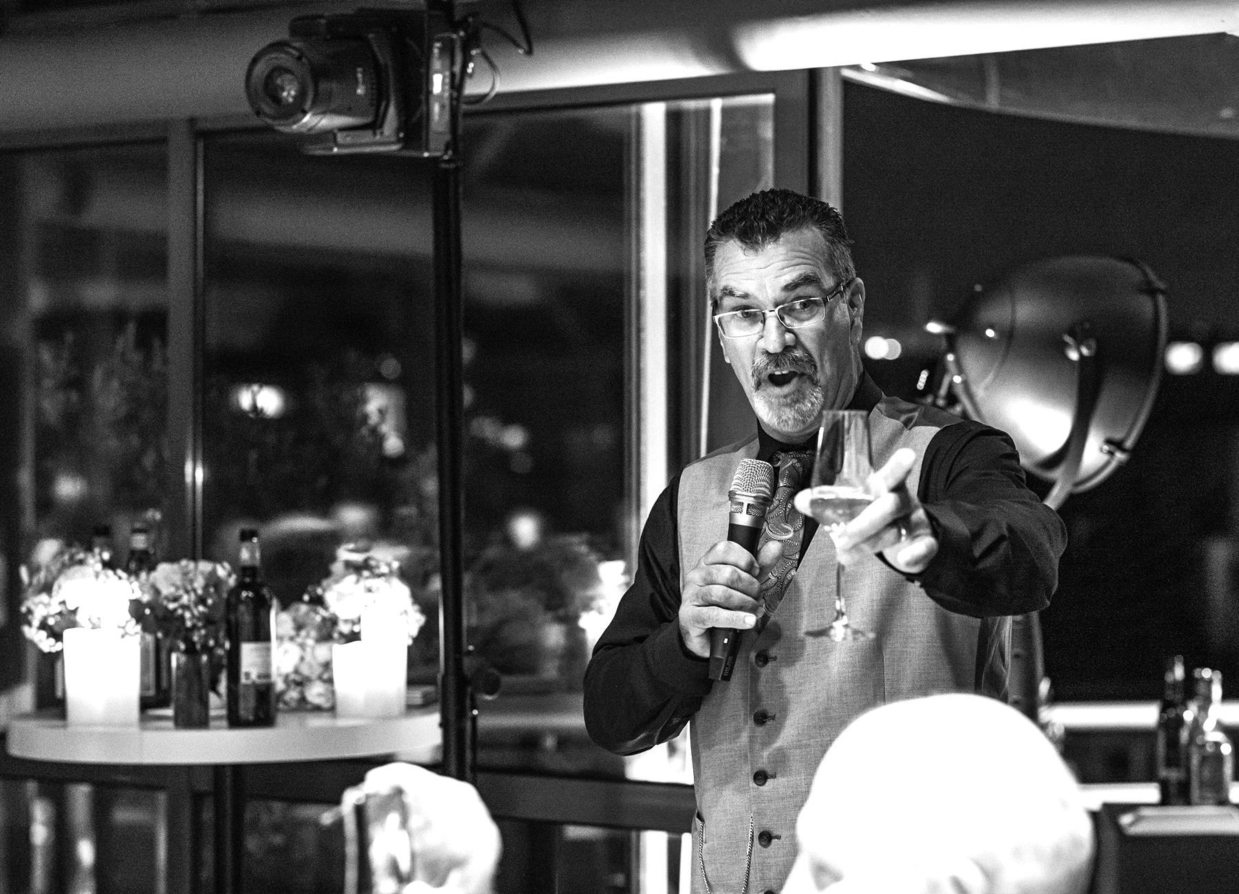 Le père de la mariée prononçant un discours lors du repas au Rooftop Grenelle à Paris, capturé en noir et blanc par Laurène Zabary