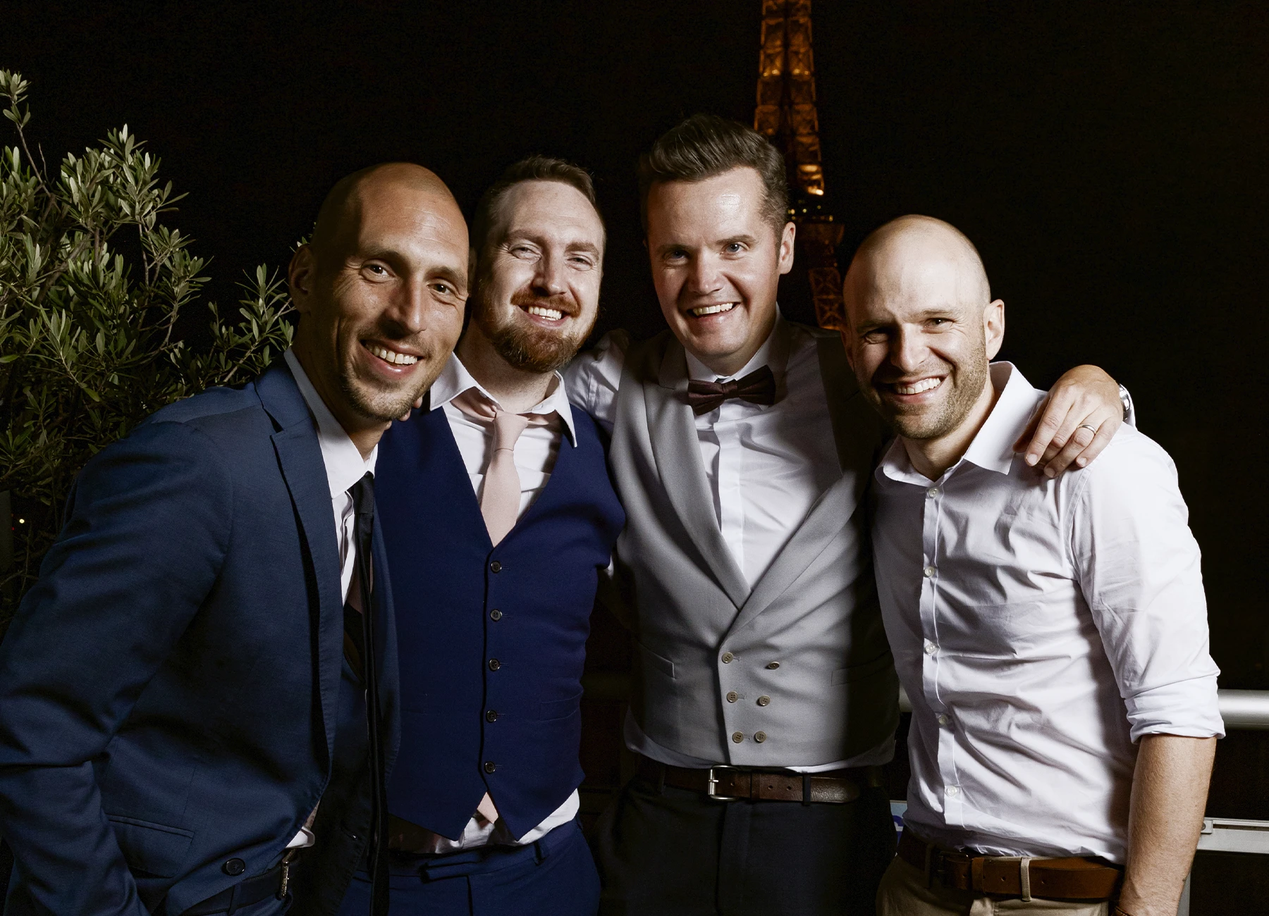 Marié et ses amis posant sur le rooftop avec la tour Eiffel en arrière-plan, capturés par Laurène Zabary, photographe de mariage à Paris.