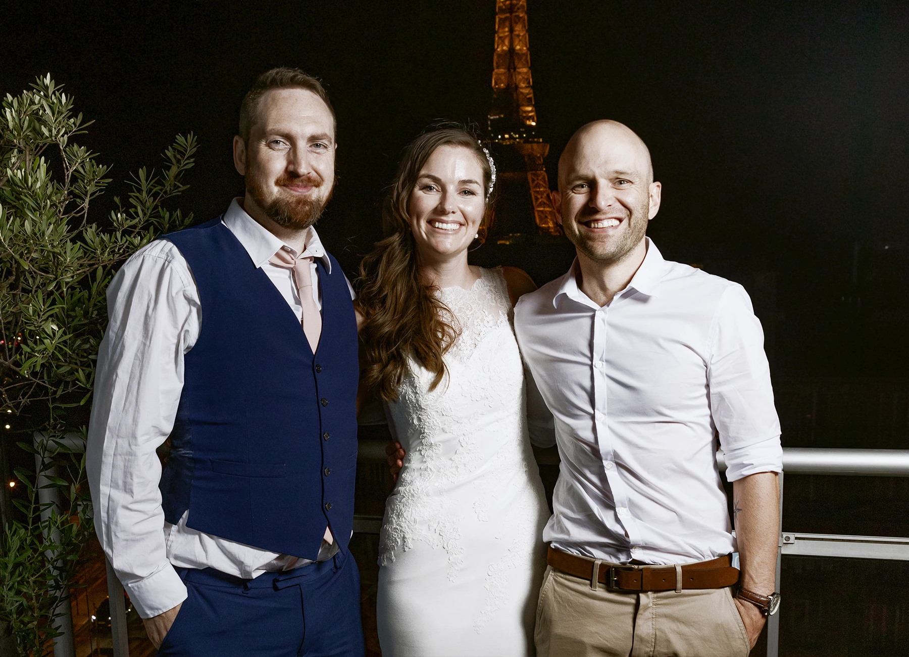 Mariée et deux invités posant sur le rooftop avec la tour Eiffel en arrière-plan, capturés par Laurène Zabary, photographe de mariage à Paris.