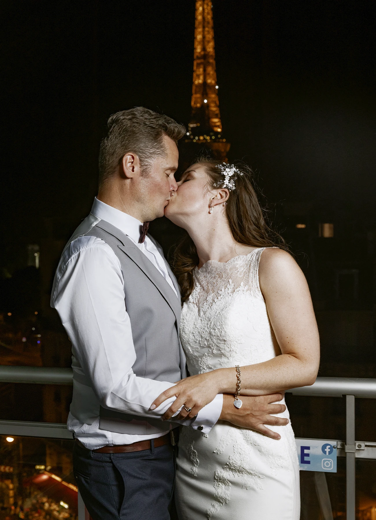 Les mariés s'embrassant sur le rooftop avec la tour Eiffel illuminée en arrière-plan, capturés par Laurène Zabary, photographe de mariage à Paris