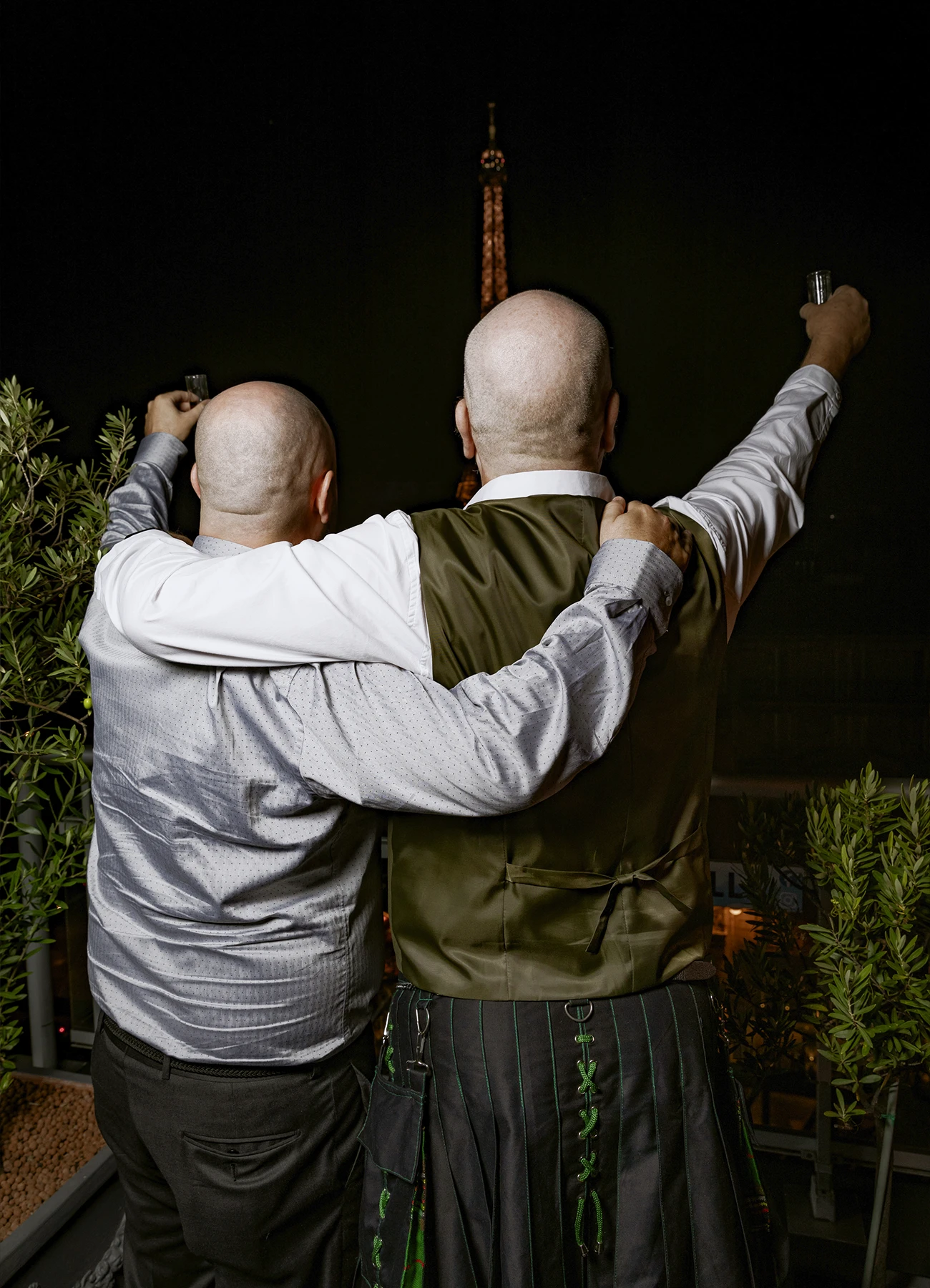 Deux hommes de dos, contemplant la tour Eiffel illuminée depuis le rooftop Grenelle à Paris, capturés par Laurène Zabary.