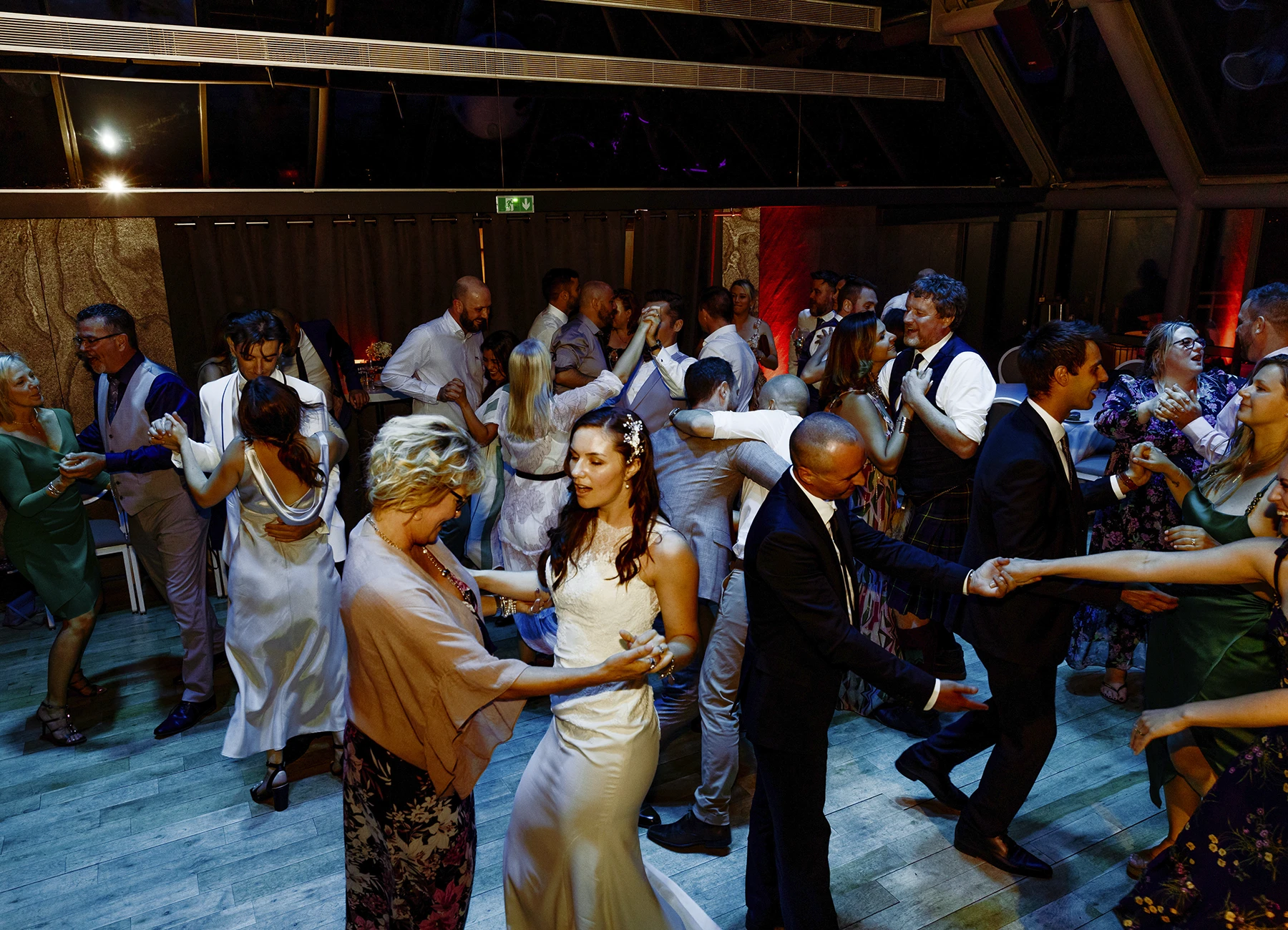 Ambiance festive de la soirée dansante avec des lumières bleues à Paris, capturés par Laurène Zabary, photographe de mariage.