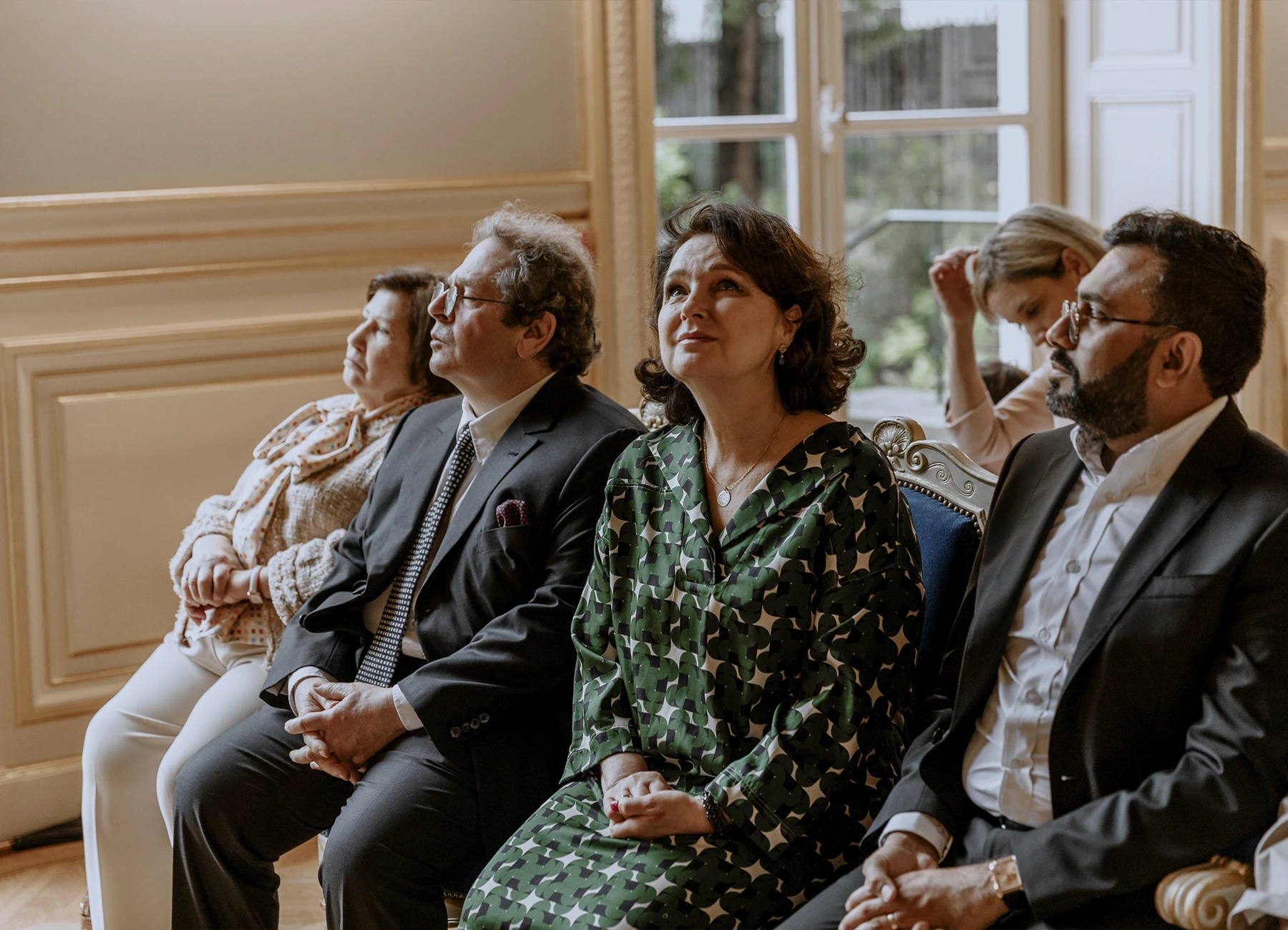 Photo du premier rang lors de la cérémonie avec la mère du marié levant les yeux pour admirer les moulures du plafond à la mairie du 7e arrondissement de Paris.