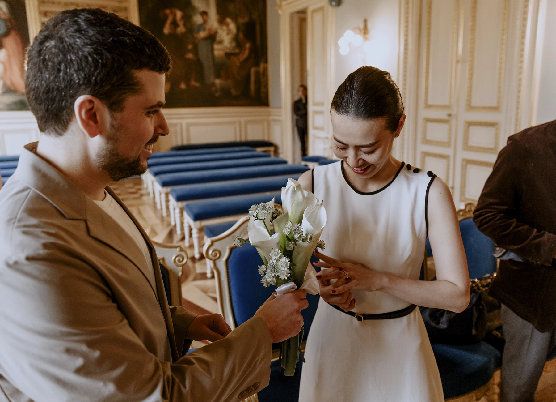 La mariée regarde son alliance en souriant pendant la cérémonie civile à la mairie du 7e arrondissement de Paris