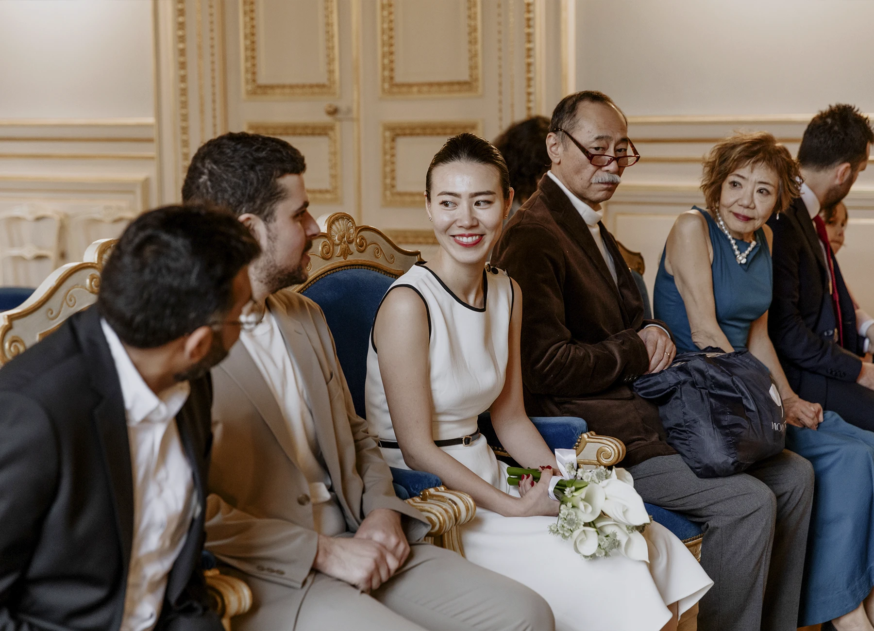 Photo du premier rang lors de la cérémonie civile avec la mariée souriante à la mairie du 7e arrondissement de Paris.