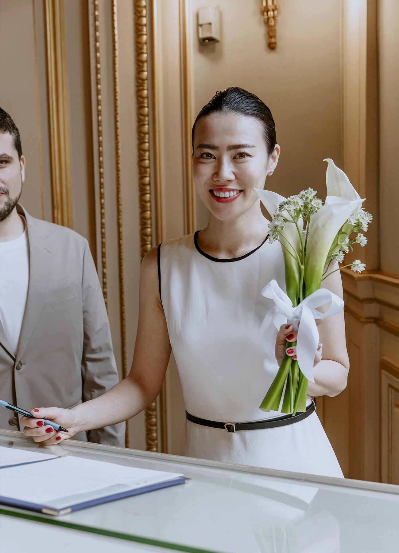 Portrait de la mariée en robe blanche et bouquet de lys Calla, juste après la signature du mariage à la mairie du 7e arrondissement de Paris.
