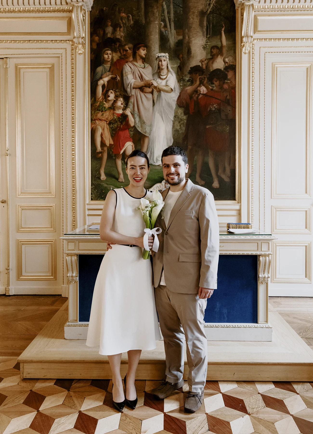 Photo en pied des mariés dans la salle de la mairie du 7e arrondissement de Paris.