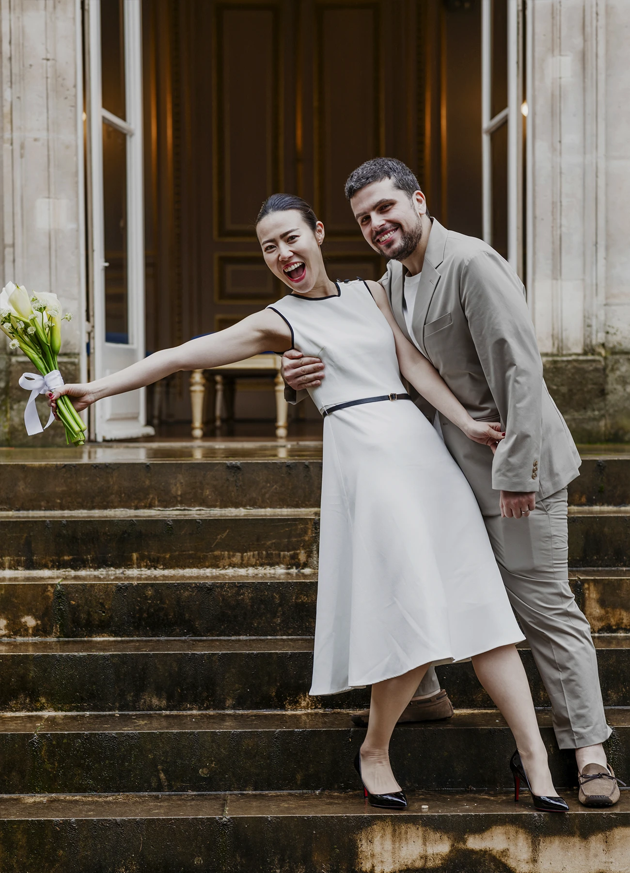 Les mariés posent et rient ensemble sur les marches de la mairie du 7e arrondissement de Paris