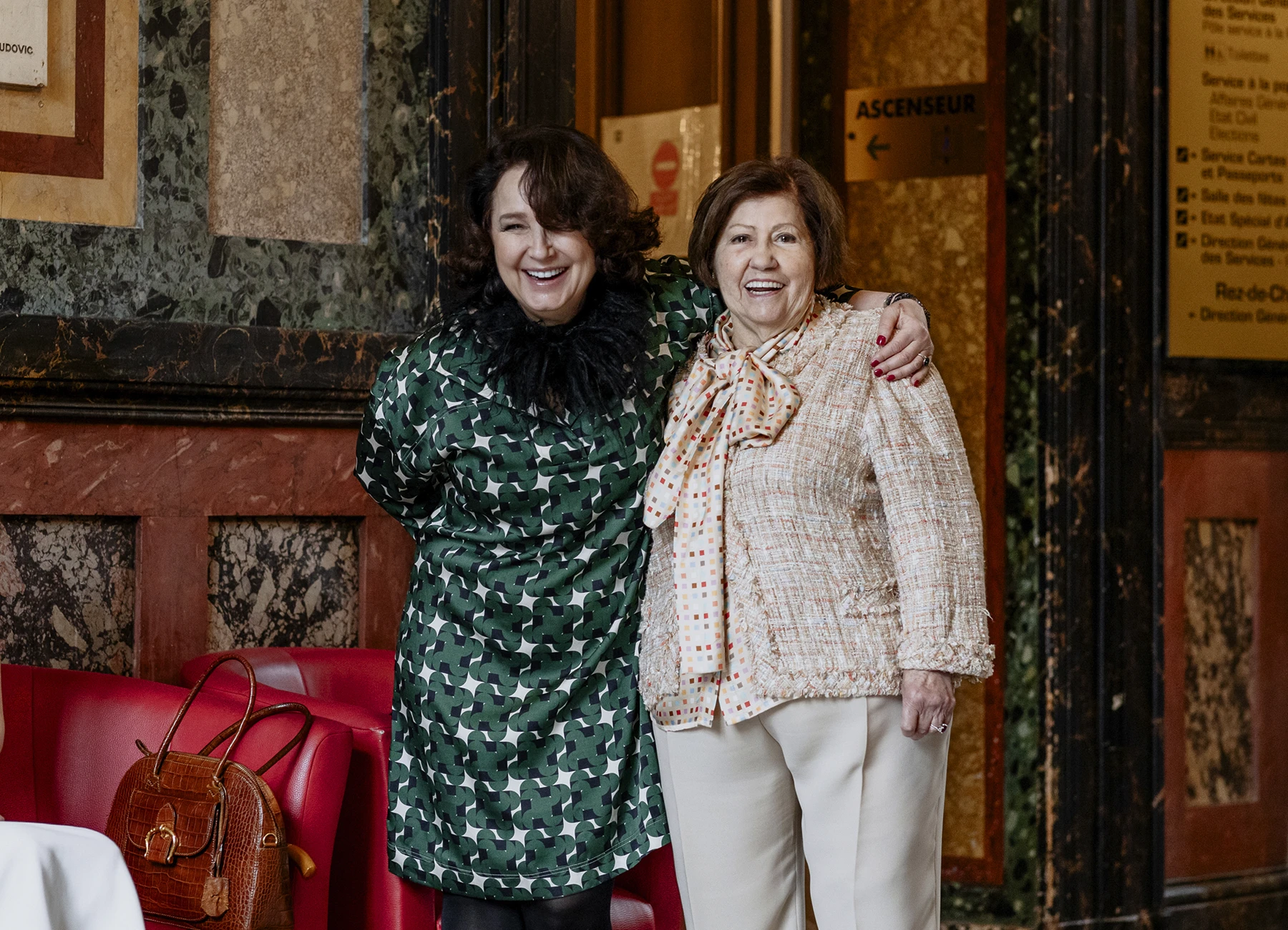Photo de la mère et de la grand-mère du marié, souriant à la caméra. La mère porte une robe verte à points blancs