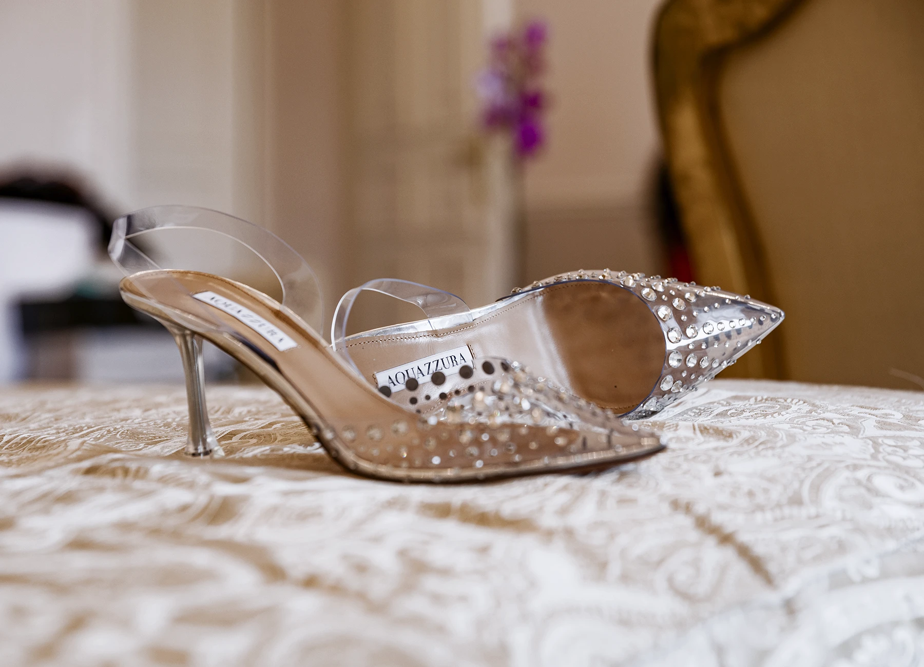 Escarpins argentés Aquazzura posés sur le lit en gros plan. Photo par Laurène Zabary