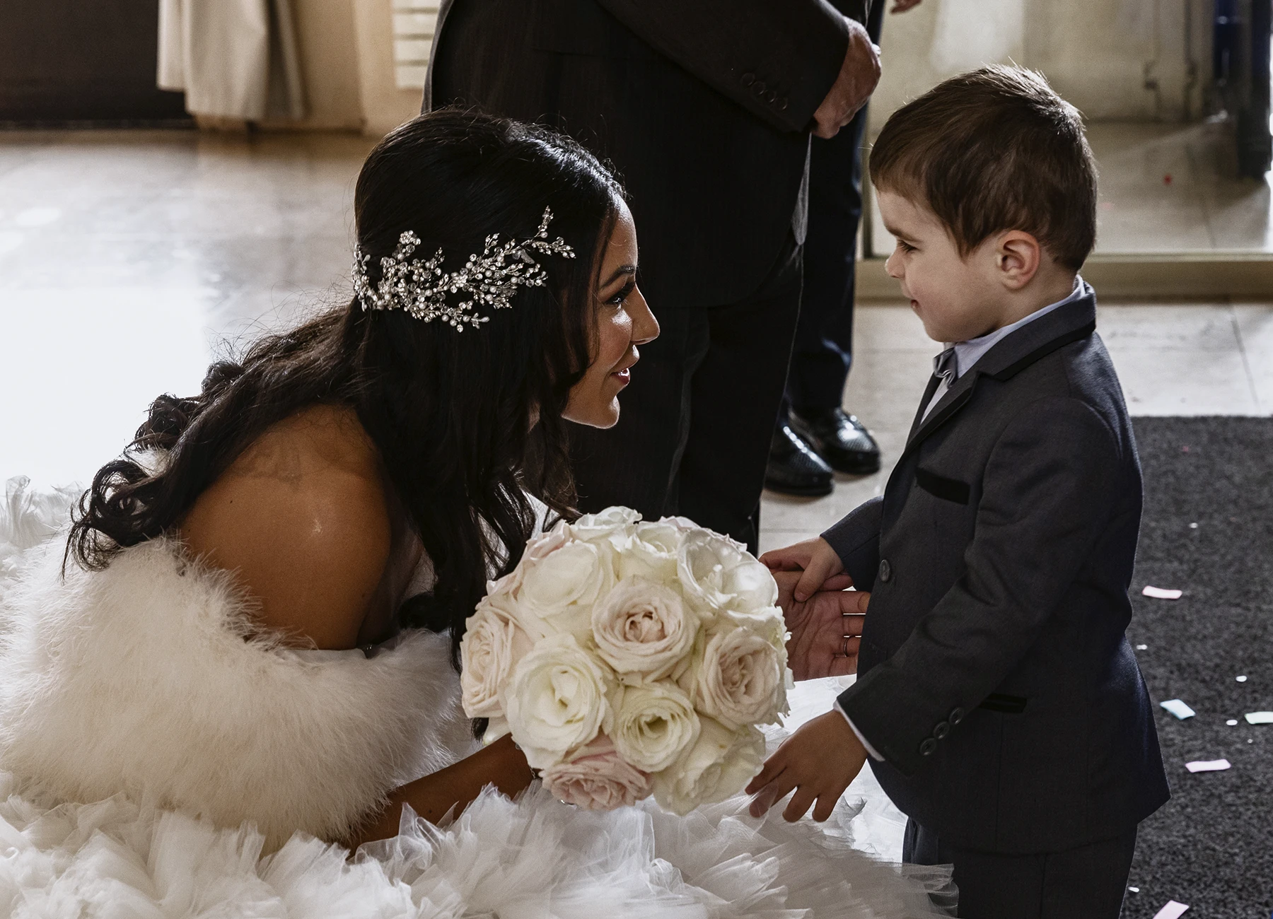 Mariée accroupie souriant à un petit garçon lors de la cérémonie civile. Photo par Laurène Zabary
