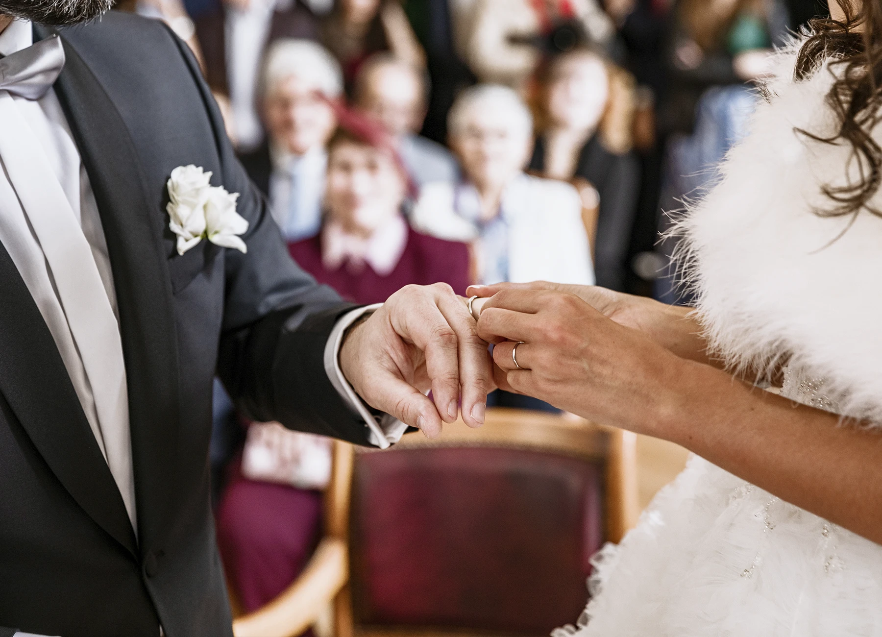 Gros plan sur la mariée mettant l'alliance au doigt de son époux. Photo par Laurène Zabary