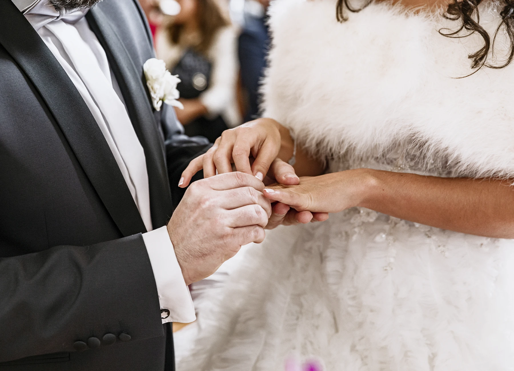 Gros plan sur le marié mettant l'alliance au doigt de son épouse. Photo par Laurène Zabary