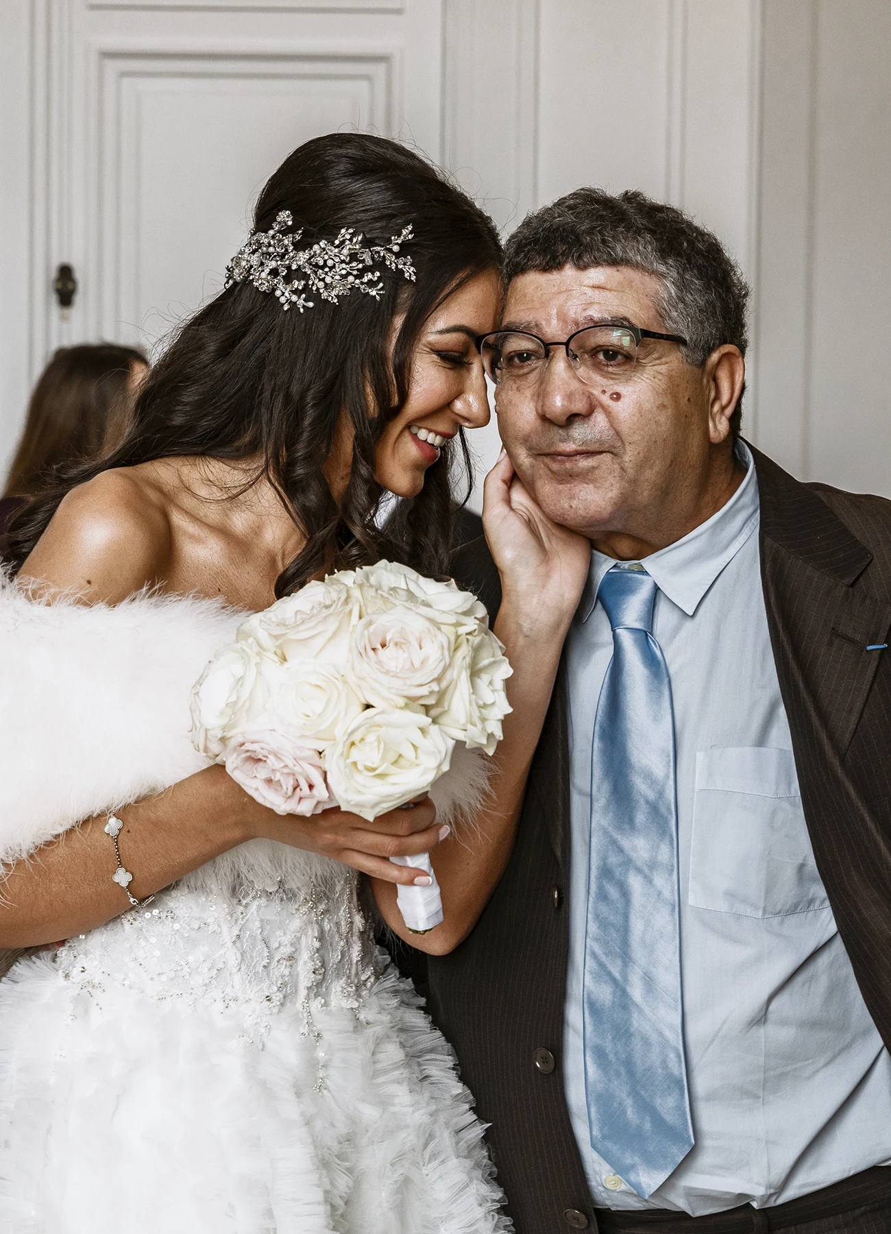 La mariée pose affectueusement la main sur la joue de son père ému, avant d'entrer à la mairie. Photo par Laurène Zabary.