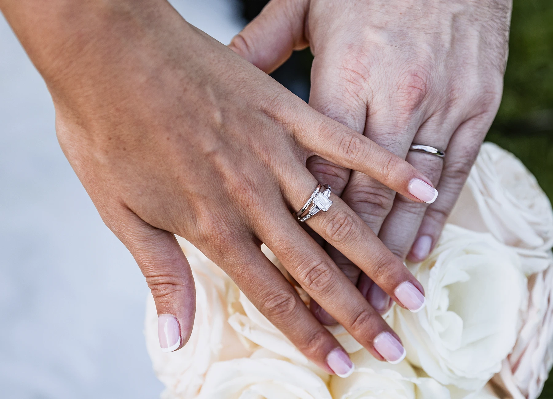 Gros plan sur les mains des mariés exhibant fièrement leurs alliances au Château Bouffémont. Photo par Laurène Zabary