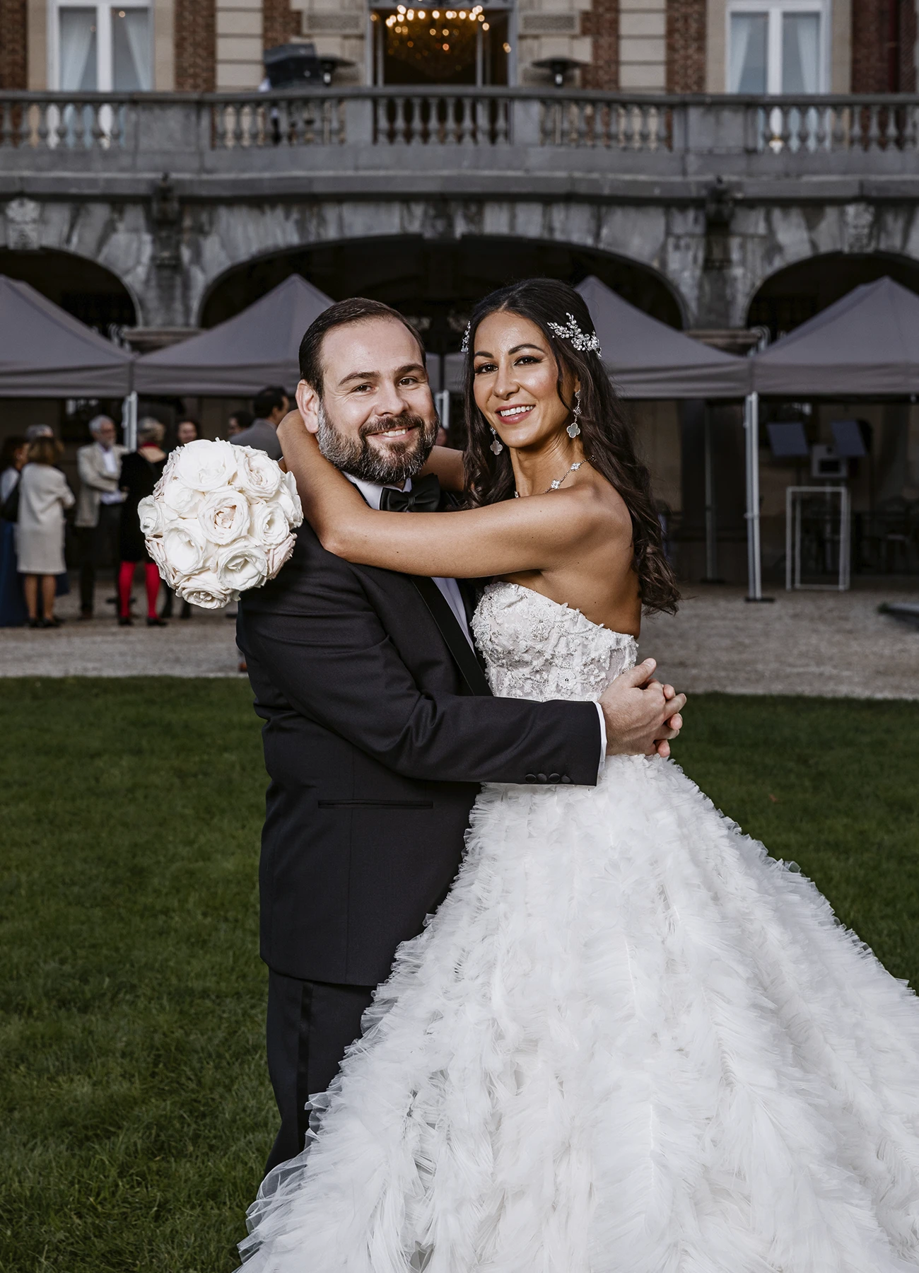 Couple amoureux posant dans les jardins du Château Bouffémont, avec le château en arrière-plan. Photo par Laurène Zabary