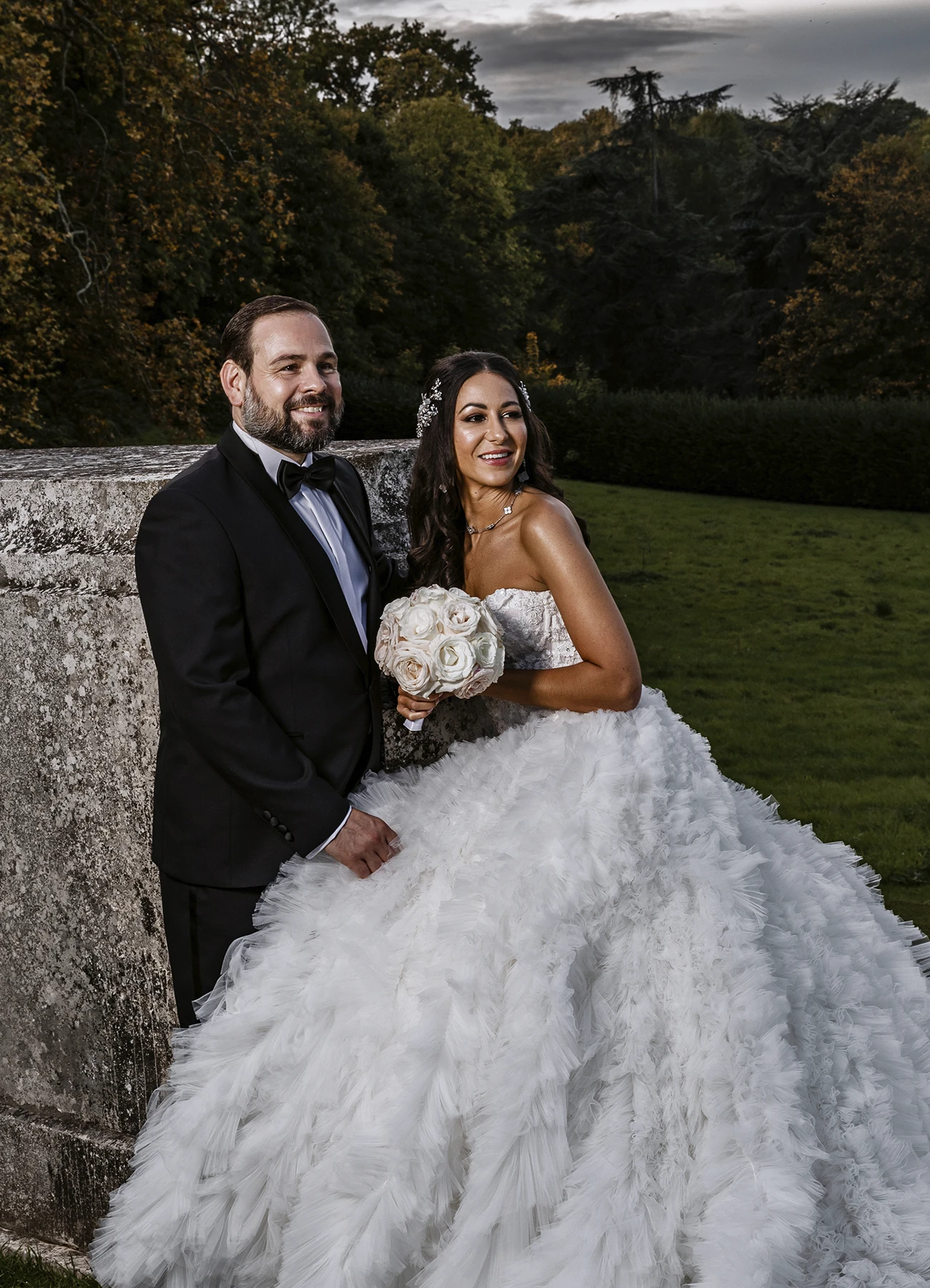 Jeunes mariés posant avec élégance dans le parc du Château Bouffémont. Photo par Laurène Zabary