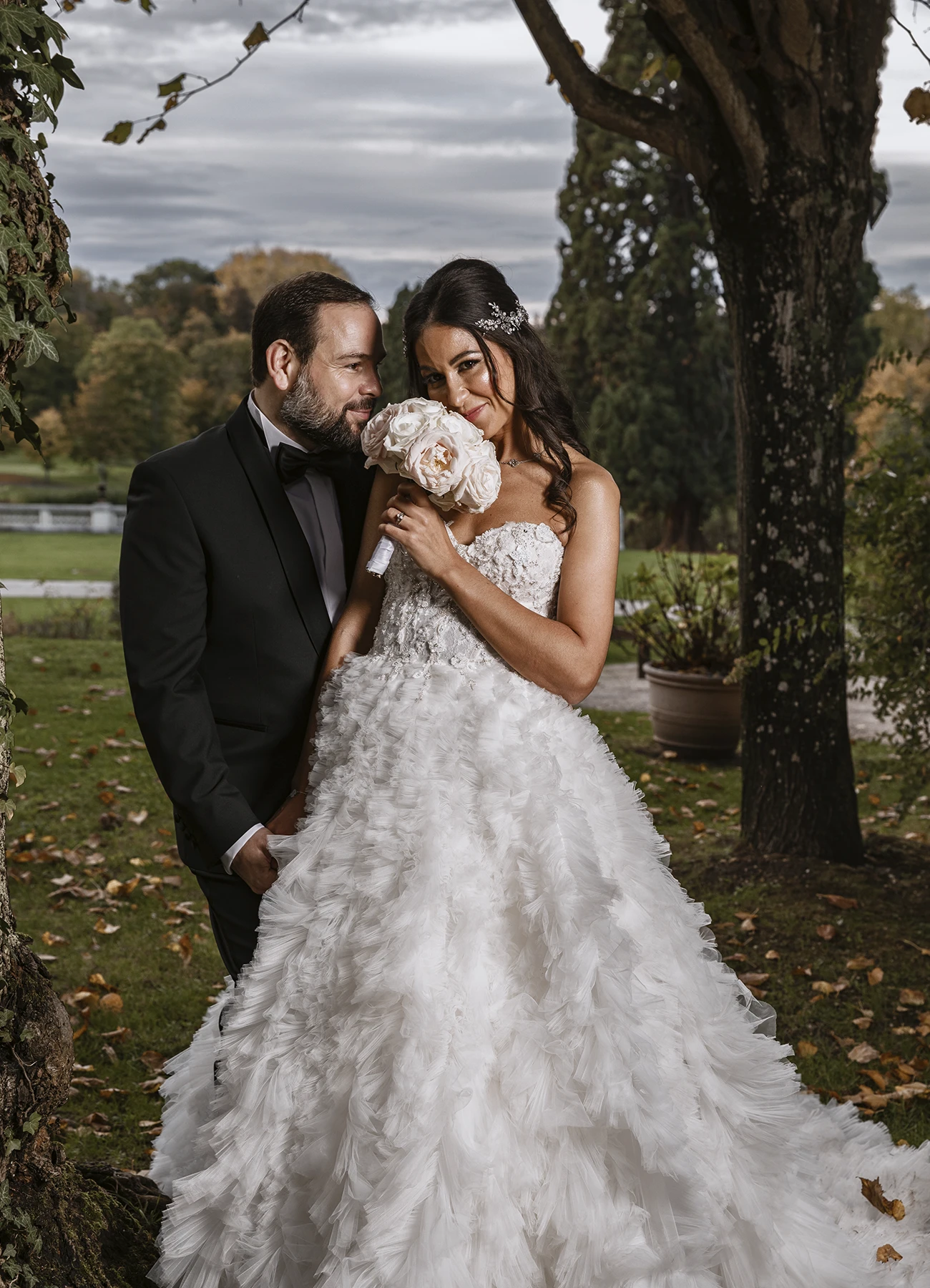 Époux et épouse debout, regardant l'objectif lors de leur shooting de mariage au Château Bouffémont. Photo par Laurène Zabary