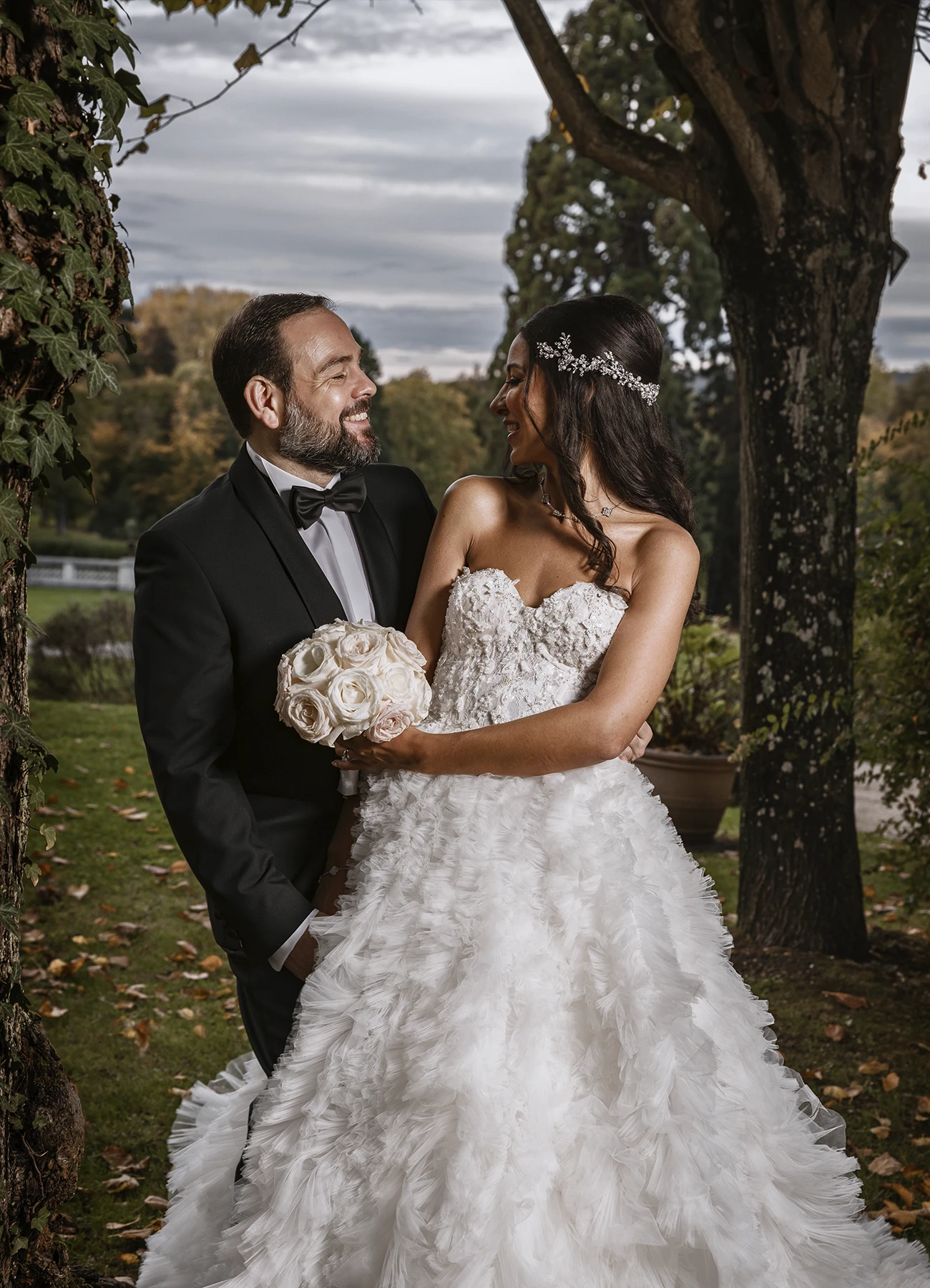 Époux et épouse debout, regardant l'objectif lors de leur shooting de mariage au Château Bouffémont. Photo par Laurène Zabary