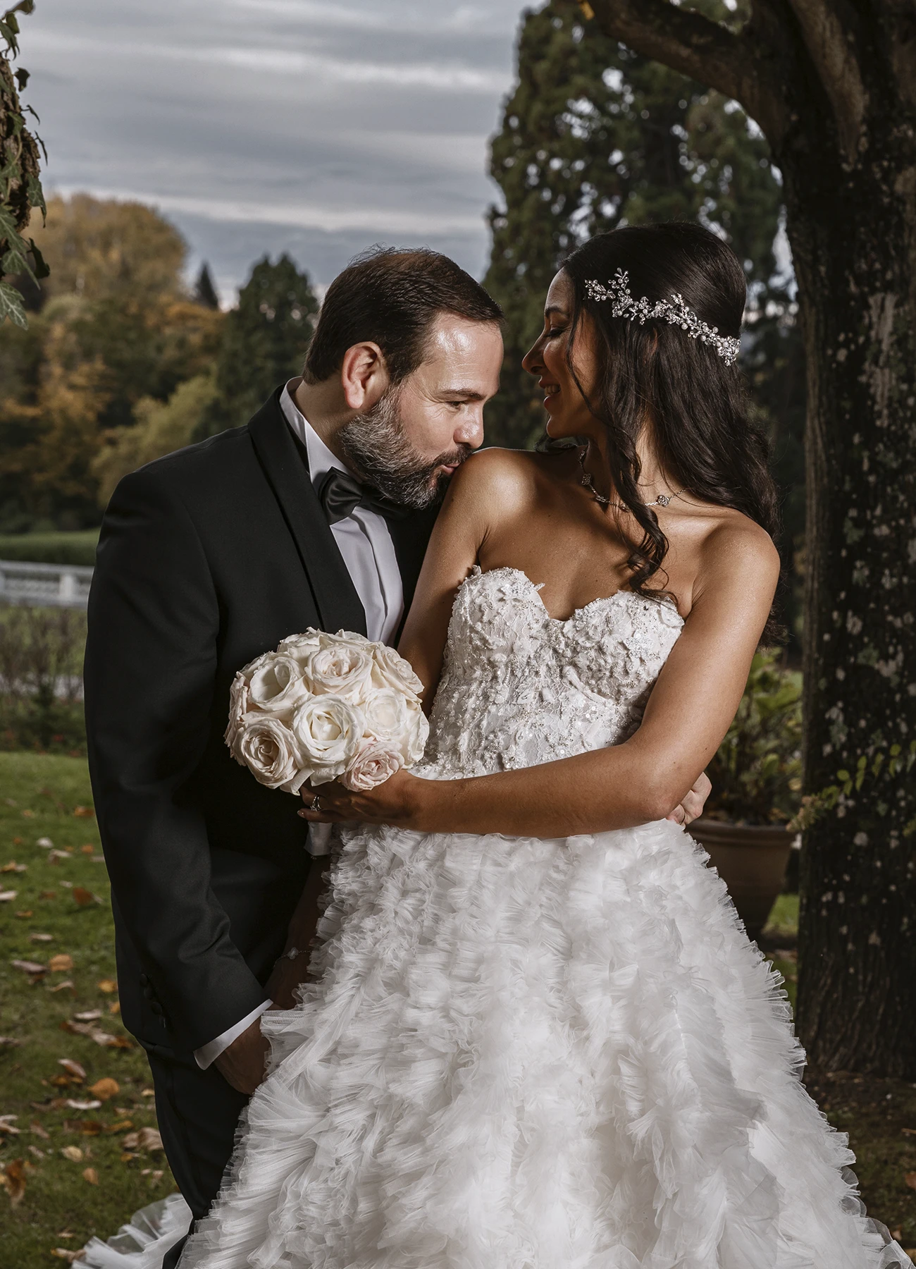 Couple de mariés debout, face à l'objectif, posant dans les jardins du Château Bouffémont. Photo par Laurène Zabary
