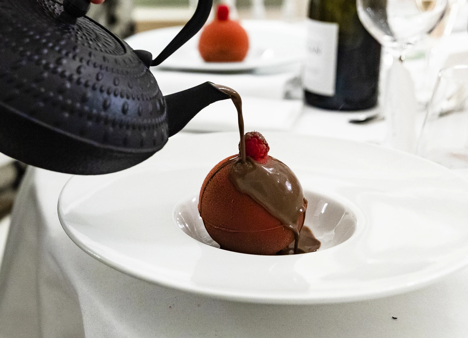 Invité versant du chocolat sur le dessert lors de la réception de mariage au Château Bouffémont. Photo par Laurène Zabary.
