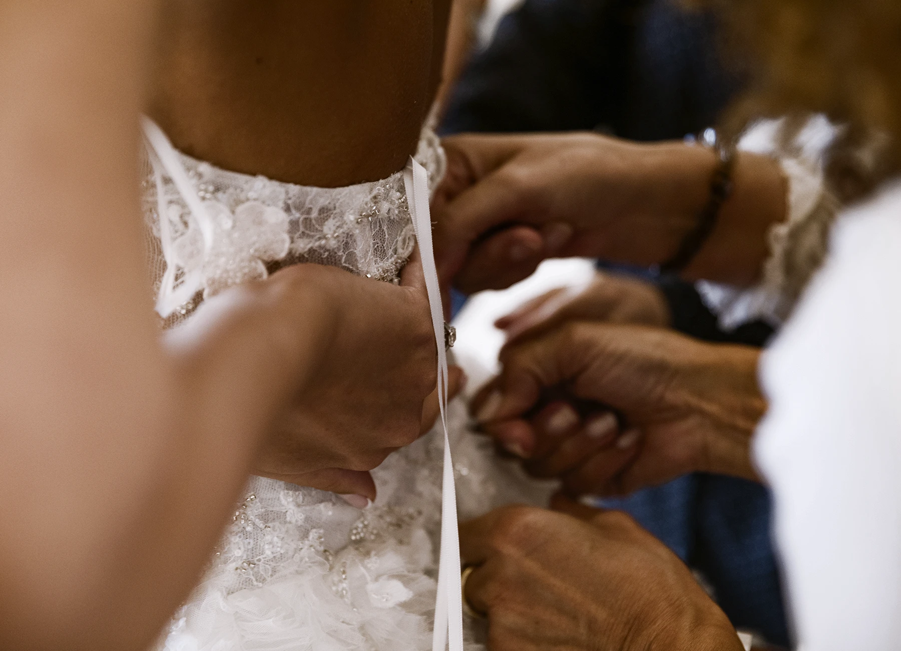 Gros plan sur le dos de la mariée pendant l'ajustement de son corset. Photo par Laurène Zabary